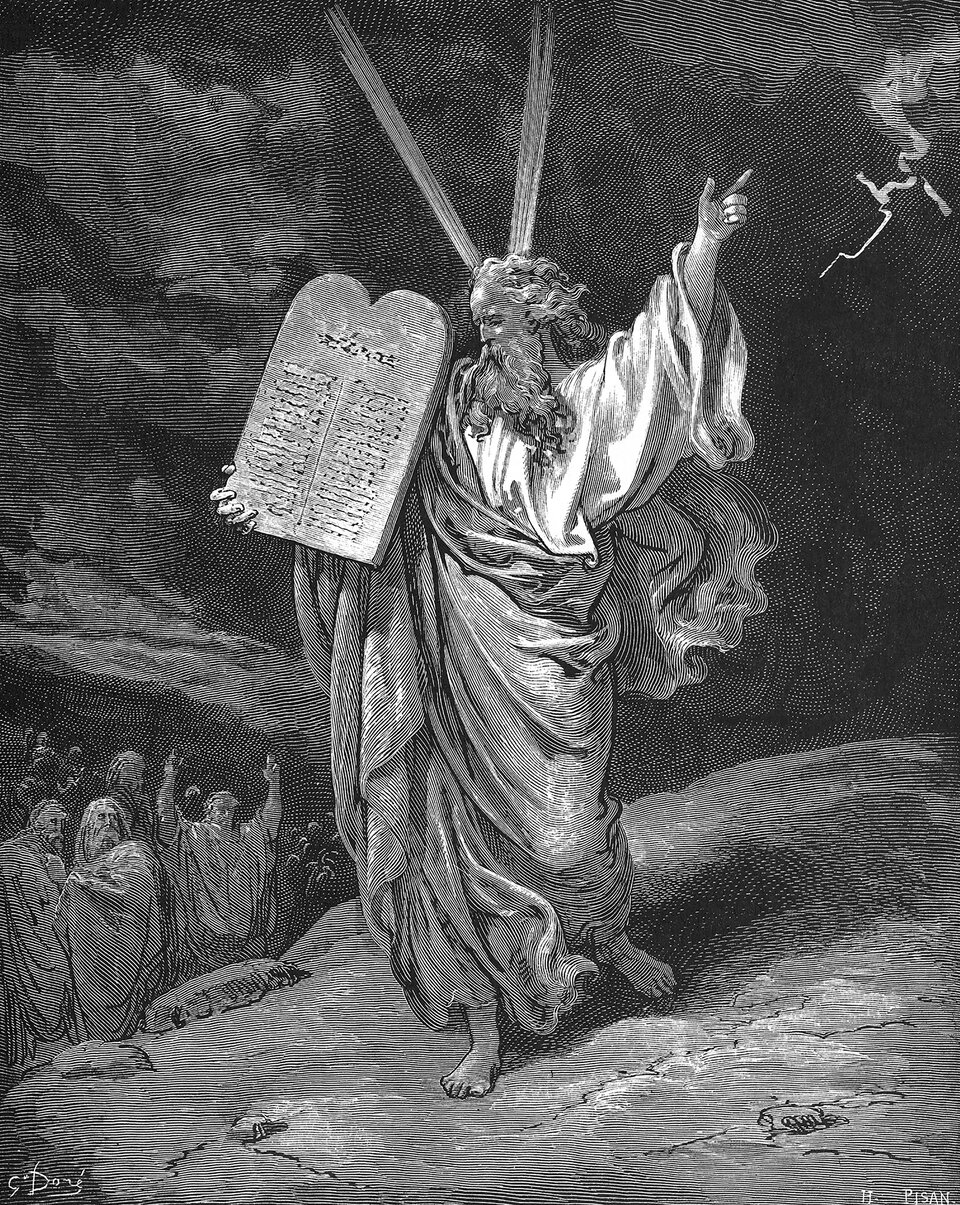 Kliknij, aby powiększyć Ilustracja przedstawia Mojżesza stojącego na górze. Jest ubrany w zwiewną szatę. Nosi długie włosy i brodę. W prawej ręce trzyma kamienną tablicę z wyrytymi na niej napisami, lewą dłoń wnosi ku niebu. Pod górą tłoczą się ludzie, którzy patrzą na Mojżesza i unoszą ku górze ręce.