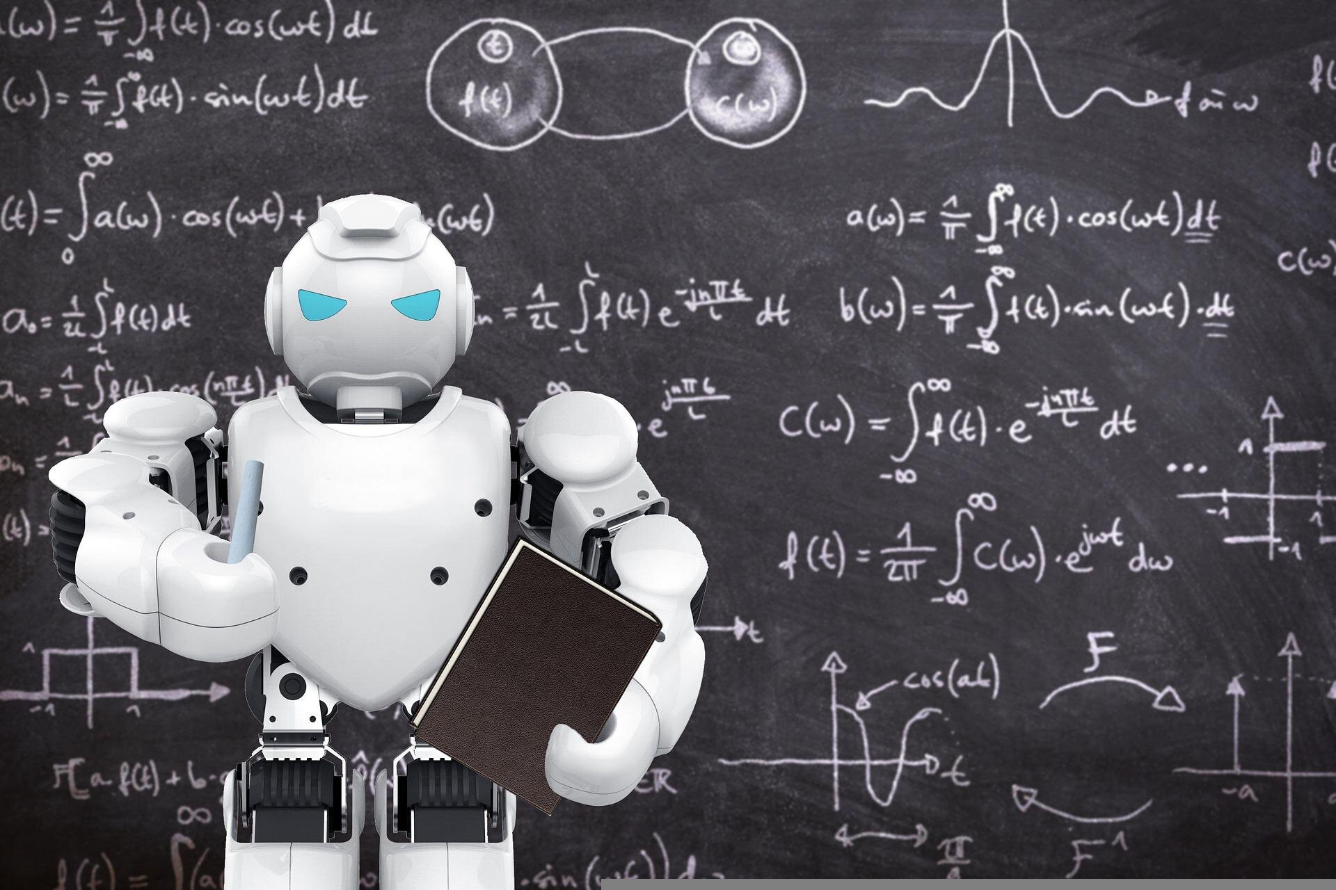Zdjęcie przedstawia stojącego na tle tablicy robota, humanoida. Robot trzyma książkę i kredę. Na tablicy zapisane są równania matematyczne.