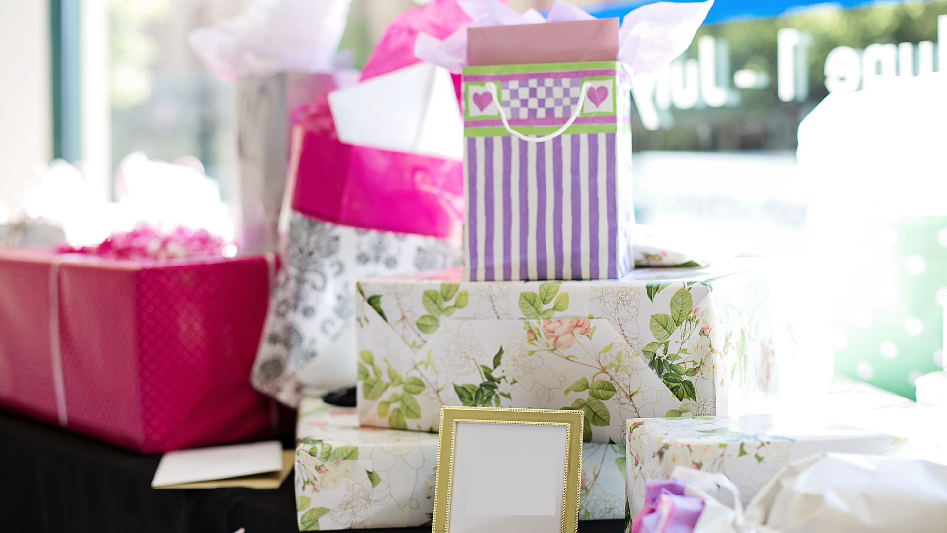 Zdjęcie przedstawia stos prezentów ślubnych.