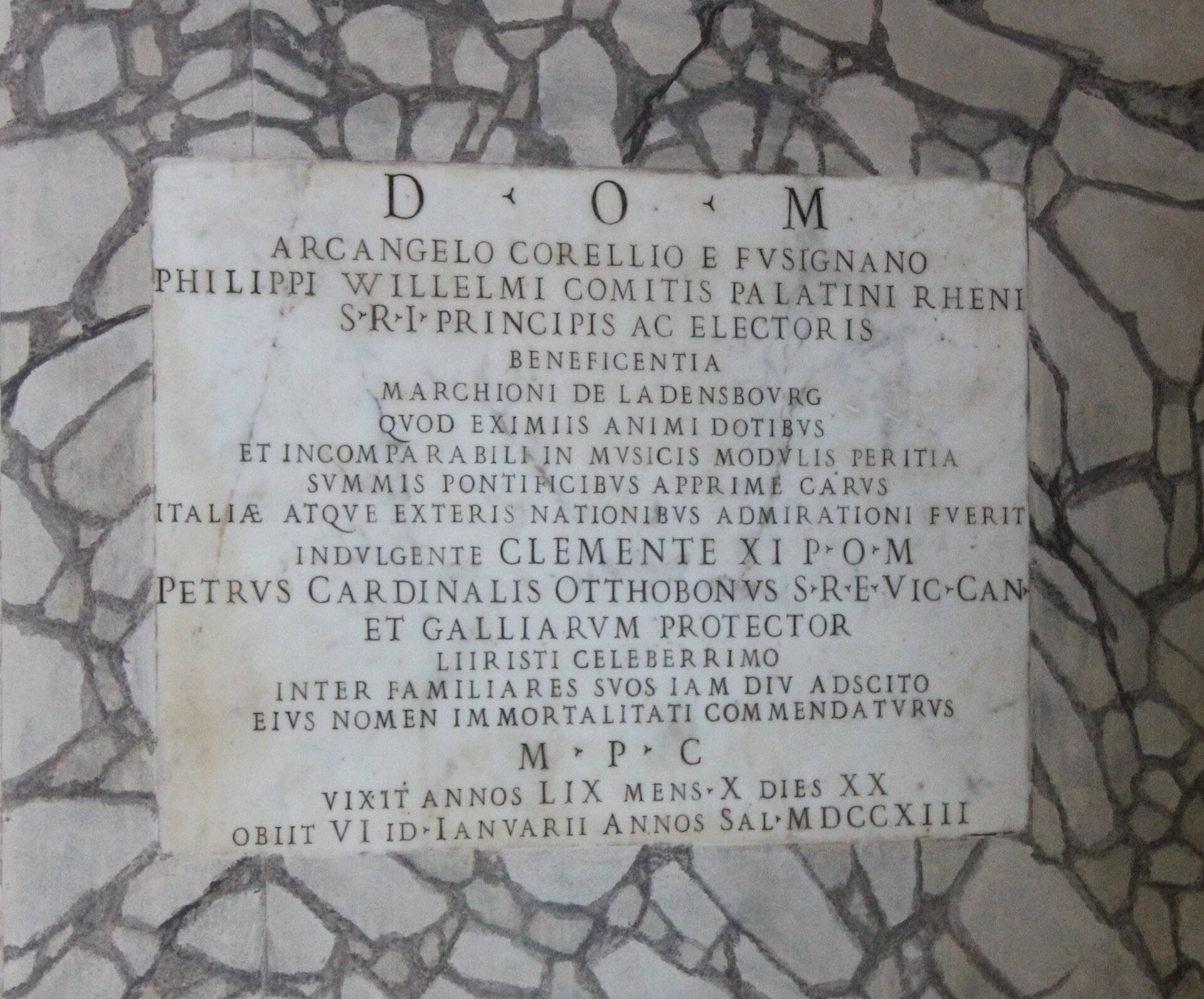 Ilustracja przedstawia: Fragment płyty nagrobnej Arcangelo Corellego znajdujący się w Panteonie, ok. 1713, Rzym, Włochy. Jest to szara kamienna tablica z wytłoczonymi napisami.