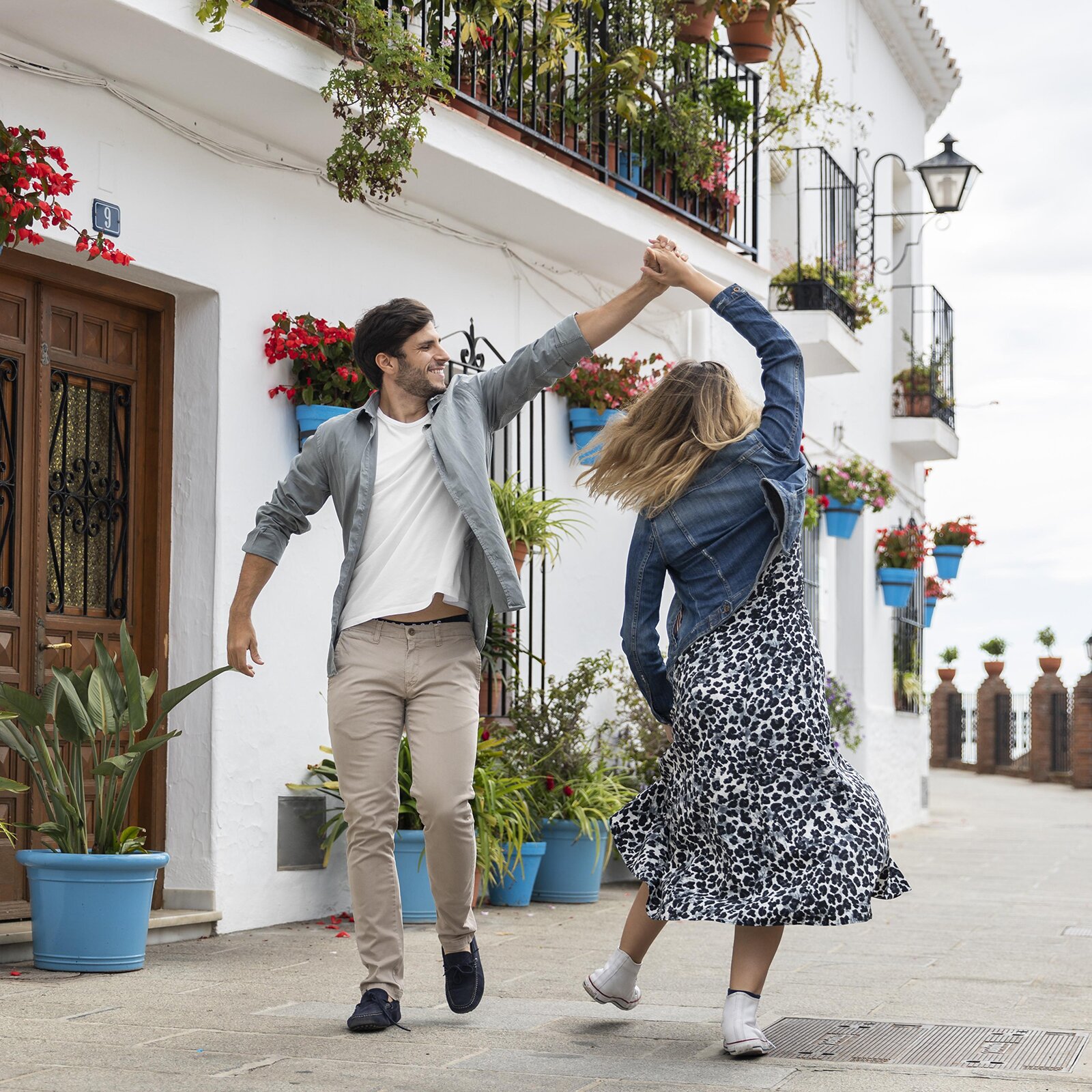 Zdjęcie przedstawia kobietę i mężczyznę tańczących na ulicznym zaułku. 