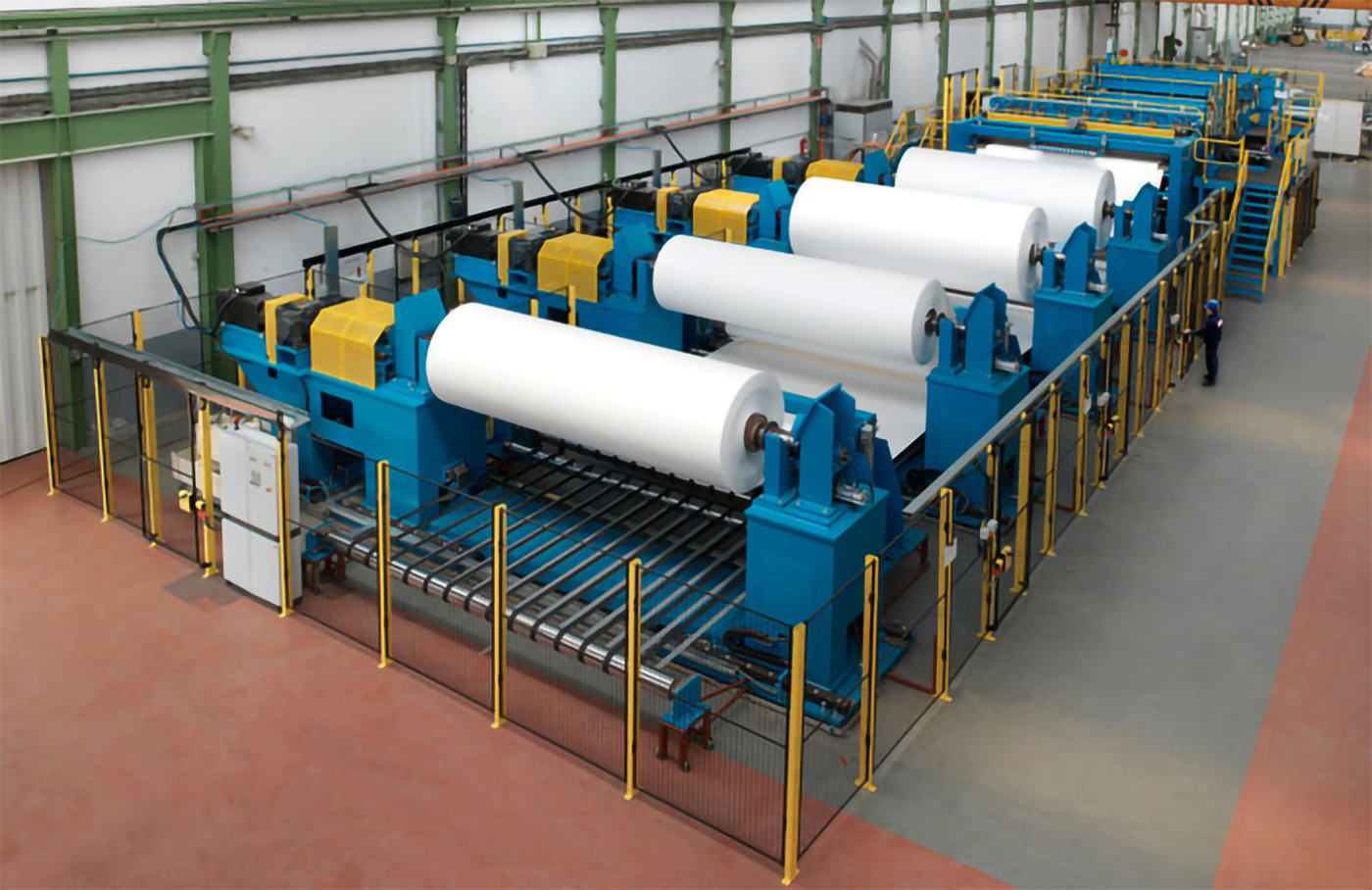 Zdjęcie ukazuje przekrawacz papieru. Jest to urządzenie wyposażone w walce, na których znajdują się odwijane wstęgi papieru oraz system odpowiedzialny za jego rozcinanie.