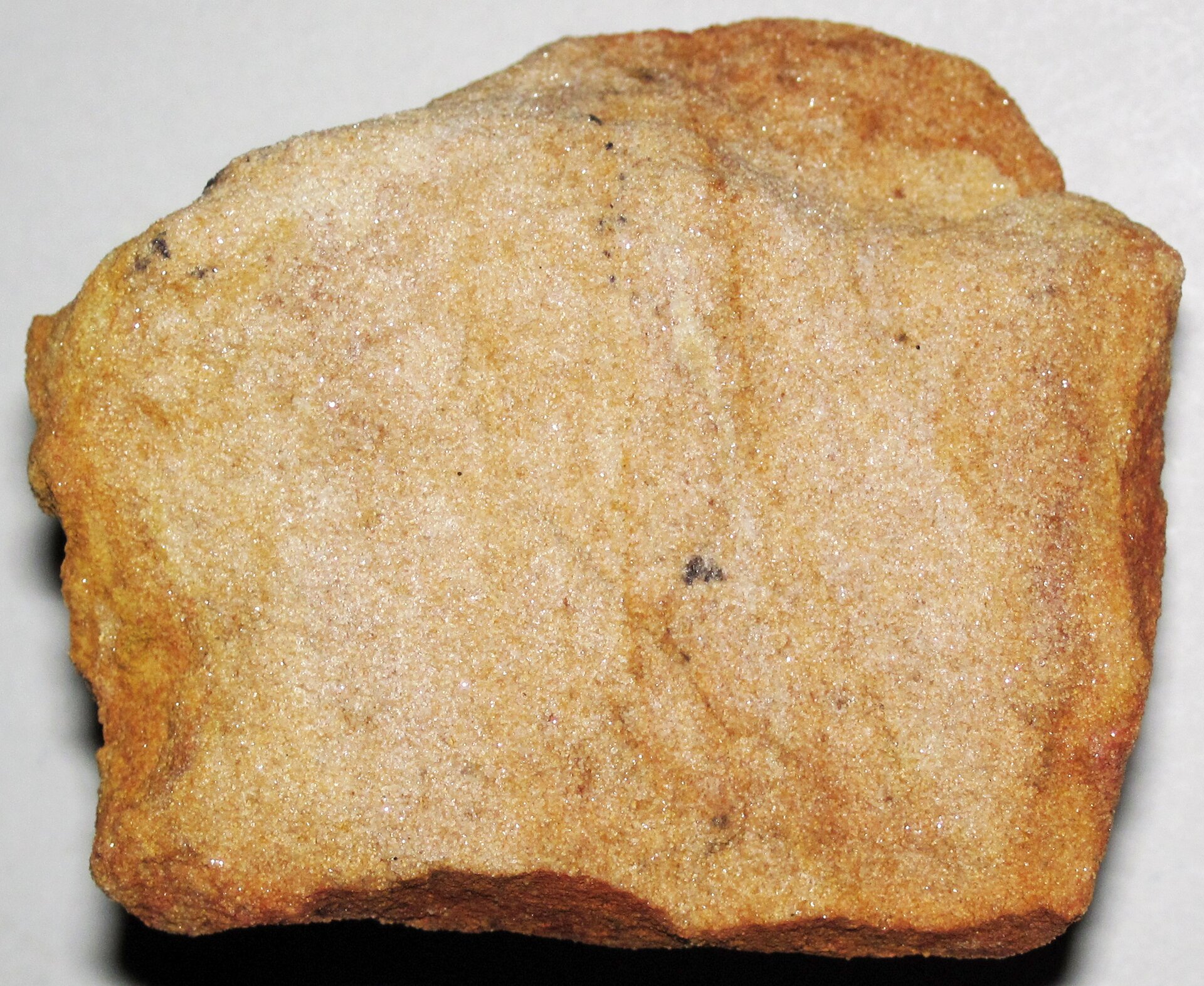 Na zdjęciu skała o ciemnopiaskowym kolorze, nieregularnych kształtach, płaskich ściankach.