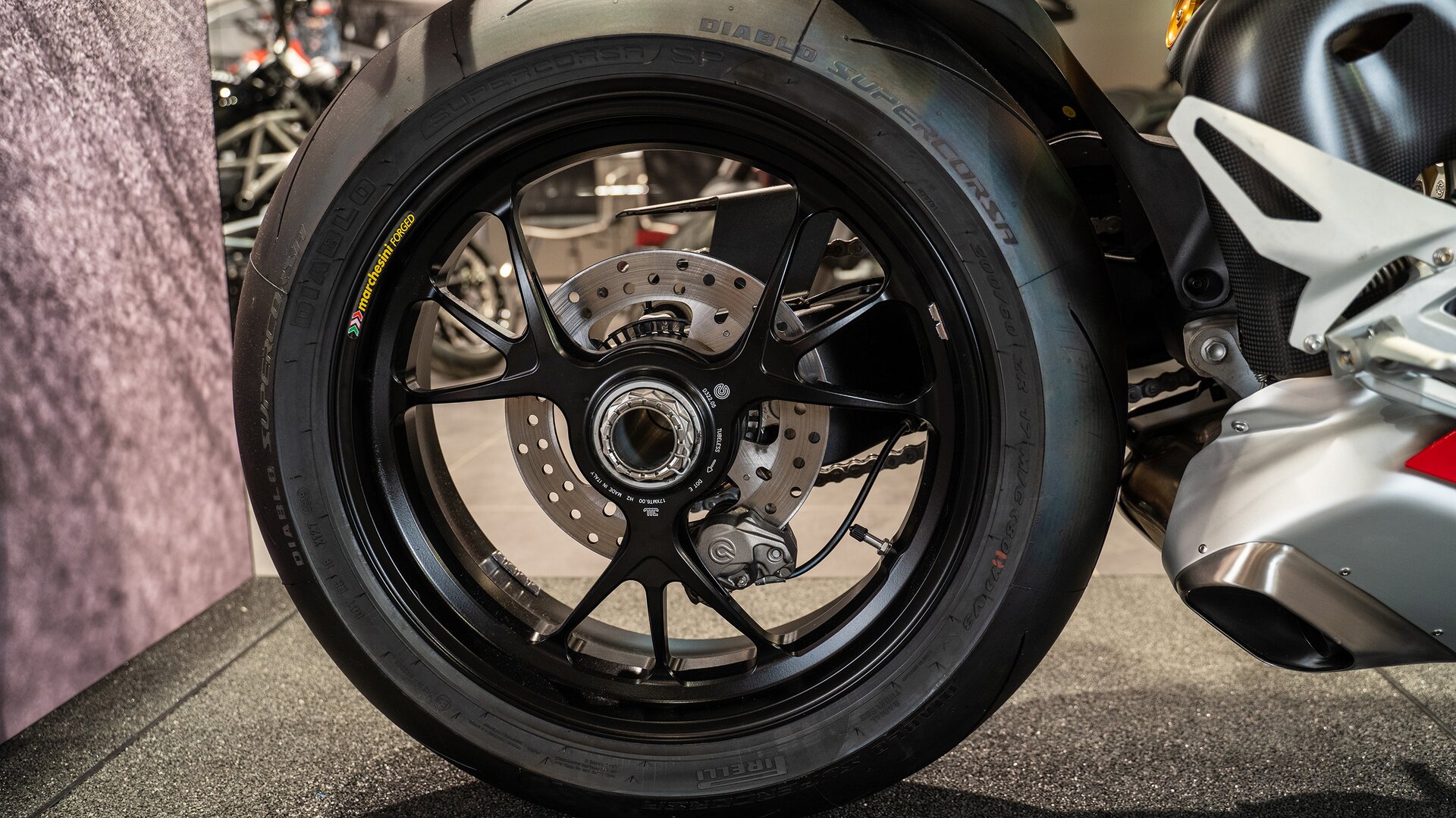 Zdjęcie przedstawia tarczę z otworami zamocowaną na tylnym kole motocykla.  