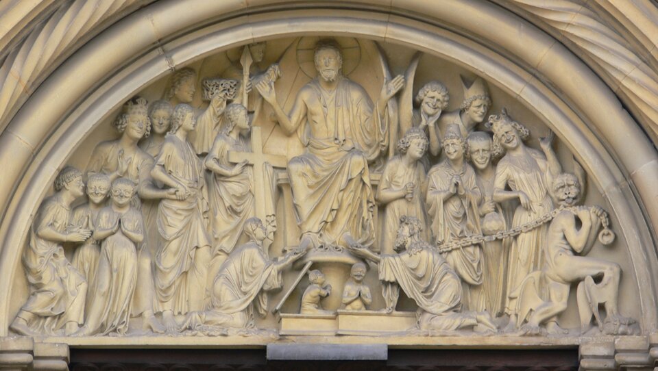 Ilustracja przedstawia tympanon z katedry w Bambergu. Ukazuje scenę - rzeźbę Sądu ostatecznego.  Pośrodku siedzi Chrystus na Majestacie. Lewą rękę ma wzniesioną do góry. Po obu stronach znajdują się postacie, dopasowane układami ciał do kształtu tympanonu. Od góry tympanon wieńczą półkoliste archiwolty. 