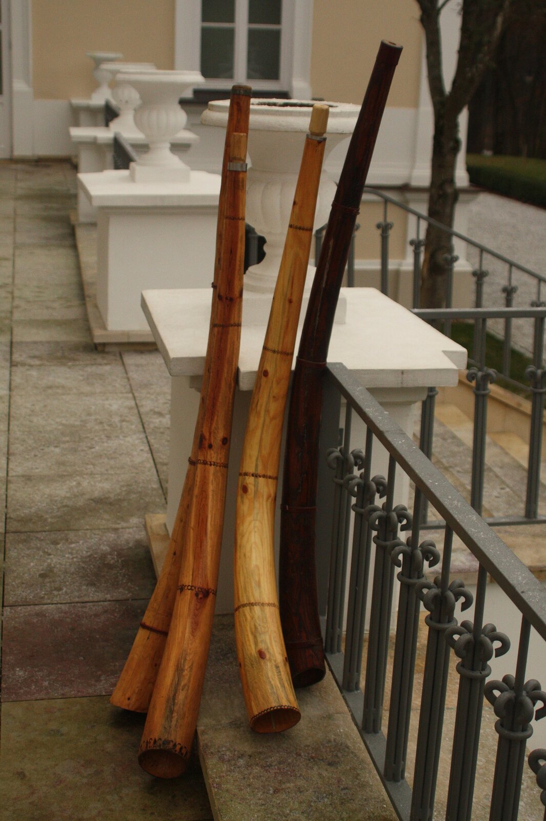 Ilustracja przedstawia cztery ligawki ułożone stojąco przy murku/bramie. Są to instrumenty ludowe z grupy aerofonów stroikowych, zbliżone do fletu prostego, o drewnianej konstrukcji. Ligawki charakteryzują się specyficznym brzmieniem, które zależy od techniki gry oraz od konstrukcji i materiału, z którego zostały wykonane. Składają się z jednego lub dwóch odcinków drewna, które są wywiercone, tworząc kanał dźwiękowy.