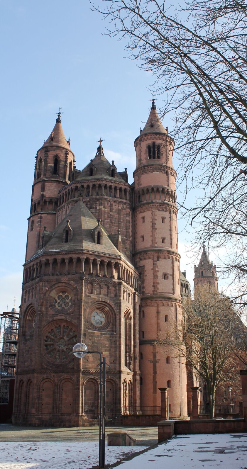 Na fotografii przedstawiono Kościół Świętego Piotra Wormacji w Niemczech w ujęciu od strony wschodniej. Na pierwszym planie przedstawione jest prezbiterium zbudowane na planie półokręgu, które posiada na ścianie wyrzeźbione łuki, natomiast powyżej umieszczone są okrągłe okna w formie rozety. W najwyższym punkcie prezbiterium znajdują się ozdobne kolumnady. Prezbiterium ma spadzisty dach ze spiczastym czubkiem. W głębi widoczna jest nawa główna wyższa od prezbiterium. Jej dach jest spadzisty, na nim znajduje się krzyż. Po bokach nawy głównej są wysokie wieże zbudowane na planie okręgu posiadające równomiernie rozmieszczone, małe okna. Z kolei na wyższych kondygnacjach znajduje się ozdobna kolumnada, a nad nią okna w dzwonnicy. Dach ma kształt spiczastego ostrosłupa. W tle widoczne są wieże naw bocznych.
