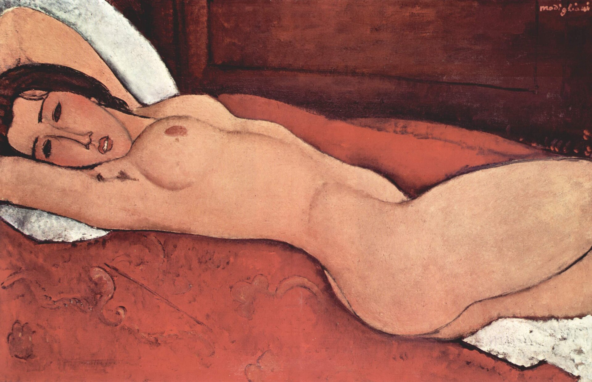 Ilustracja przedstawia obraz Amedeo Modigliani pt. „Akt leżący z rękami skrzyżowanymi pod głową”. Na obrazie znajduje się leżąca naga kobieta, która ma uniesione ręce ku górze. Leży na czerwonym kocu pod głową ma białą poduszkę.