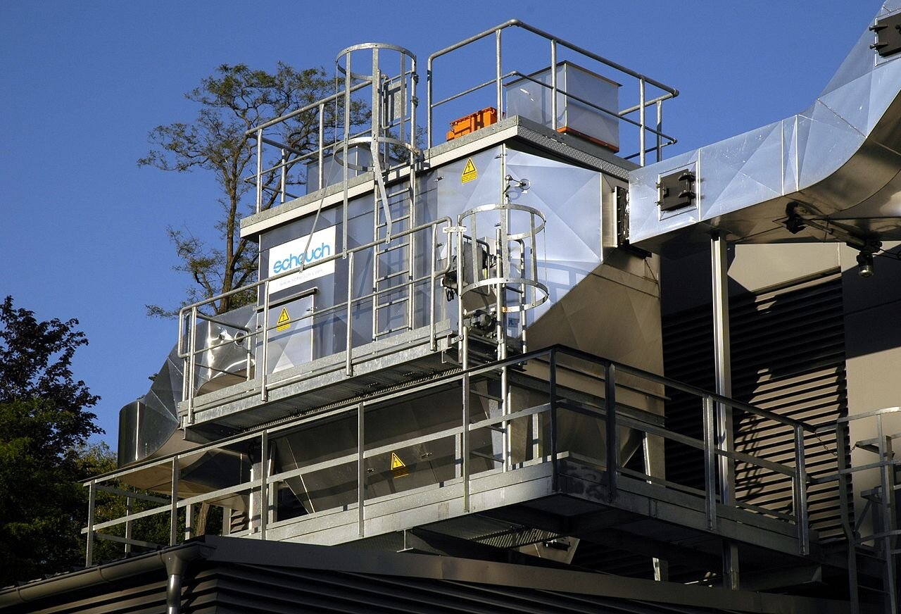 Na zdjęciu widać elektrofiltr elektrociepłowni. Konstrukcja przypomina wielościan wykonany z błyszczącej, nierdzewnej stali. W konstrukcji są widoczne metalowe, na stałe przytwierdzone drabinki pozwalające dostać się na poziomy konstrukcji. 