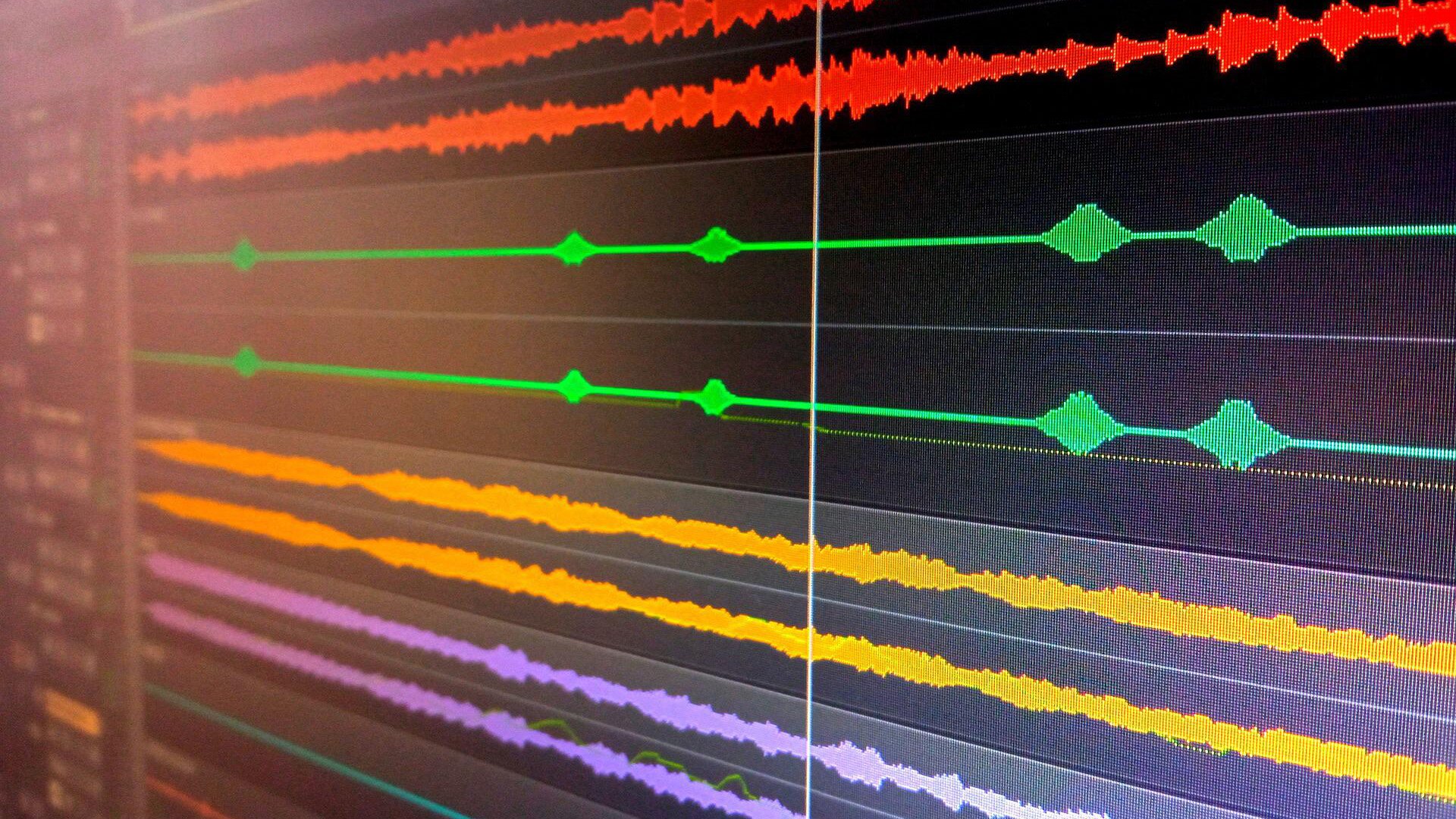 Zdjęcie przedstawia czarny prostokąt, obrazujący monitor komputera, na którym widoczne są delikatnie poszarpane linie poziome, w kolorze, od góry: dwie czerwone, dwie zielone, dwie żółte i dwie jasnofioletowe, umiejscowione względem oglądającego pod lekki kątem. Każda z tych linii obrazuje źródła dźwięku.