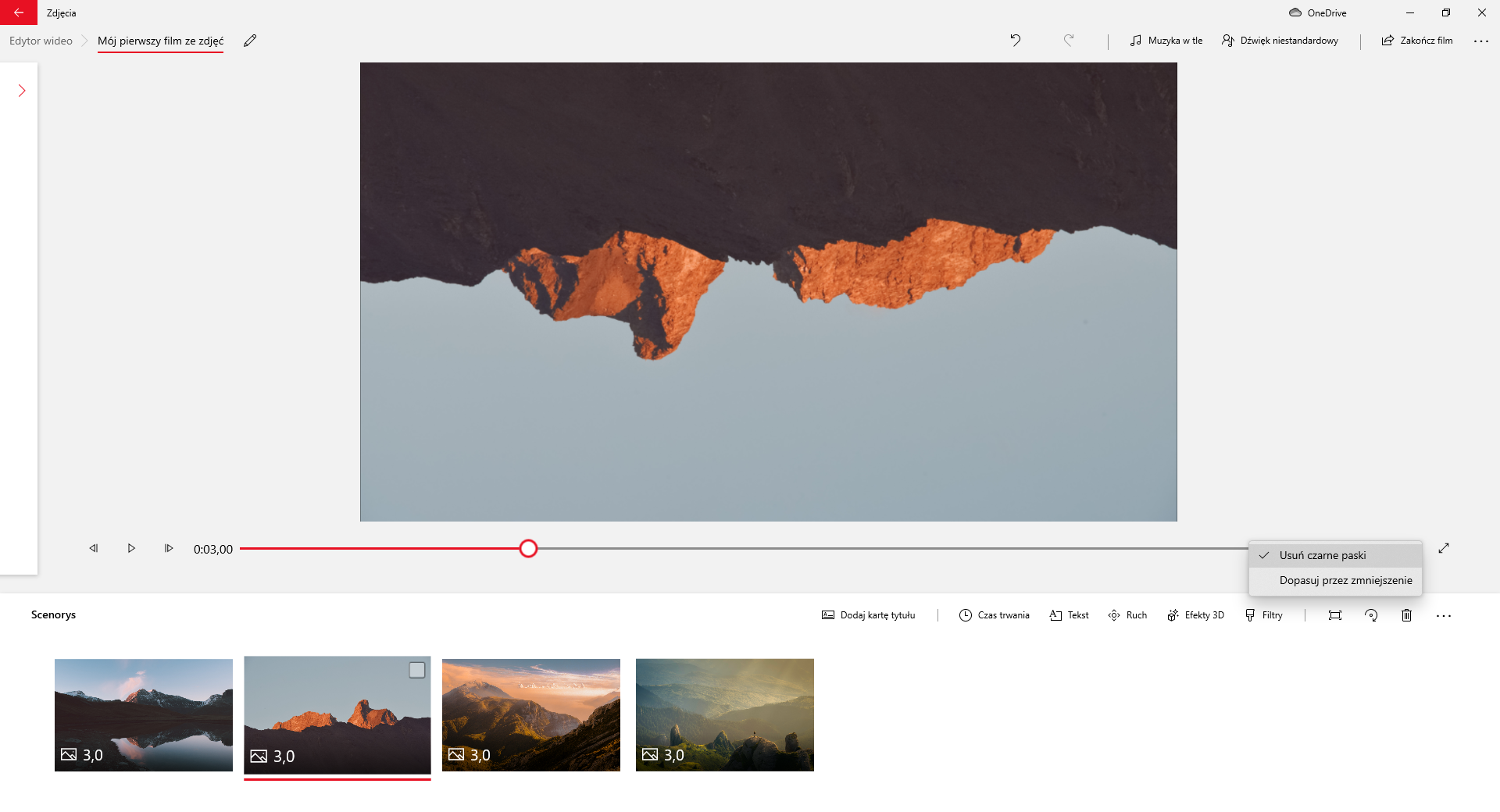 Na zrzucie ekranu przedstawiono sposób usuwania czarnego obramowania wokół zdjęć w aplikacji Edytor Wideo. Ekran roboczy aplikacji jest podzielony na dwie sekcje. W górnej części znajduje się ścieżka z wybranymi zakładkami: edytor wideo, mój pierwszy film ze zdjęć. Za nią widoczny jest przycisk z rysunkiem ołówka. Po prawej stronie aplikacji widoczne są przyciski: strzałka z grotem skierowanym w lewo, strzałka z grotem skierowanym w prawo, muzyka w tle, dźwięk niestandardowy, zakończ film i trzy kropki rozwijające więcej opcji.Poniżej widoczne jest okno edycji filmu. Główną cześć okna stanowi prostokątny obszar na którym wyświetlany jest film. Przykładowo jest to klatka filmowa pokazujący górzysty teren. Fotografia jest odwrócona górą do dołu. Obraz nie ma czarnego obramowania. Pod obszarem filmowym umieszczony jest suwak pokazujący czas trwania. Na suwaku jest okrągły znaczki czasu.Po lewej stronie suwaka znajduje się przycisk z narysowanym grotem strzałki skierowanym w lewo, przycisk , przycisk z narysowanym grotem zwróconym w prawo oraz informacja o czasie trwania filmu. Z prawej strony suwaka widoczna jest informacja z czasem trwania filmu praz przycisk przedstawiający prostą na końcu której znajdują się groty strzałek. Groty są skierowane na zewnątrz.Pod suwakiem znajduje się sekcja: scenorys. W sekcji scenorysu widoczne są cztery obrazy przedstawiające tereny górskie. W lewym dolnym rogu obrazów znajduje się cyfry. Wszystkie obrazy mają cyfrę trzy ostatni cyfrę dziesięć.W prawym górnym rogu sekcji scenorysu umieszczone są przyciski: dodaj kartę tytułu, czas trwania, tekst, ruch, efekty trzy de, filtry, przycisk z symbolem prostokąta w narożach którego znajdują się okręgi, przycisk z symbolem punktu wokół którego prowadzona jest strzałka której grot skierowany jest w dół, przycisk kosza, oraz trzy kropki po naciśnięciu których pojawia się więcej opcji.Drugi obraz jest zaznaczony. Na pierwszym przycisku za paskiem postępu filmu widoczne jest rozwinięte  kontekstowe. Opcje : usuń czarne paski, opasuj przez zmniejszenie. Opcja usuń czarne paski jest zaznaczona.