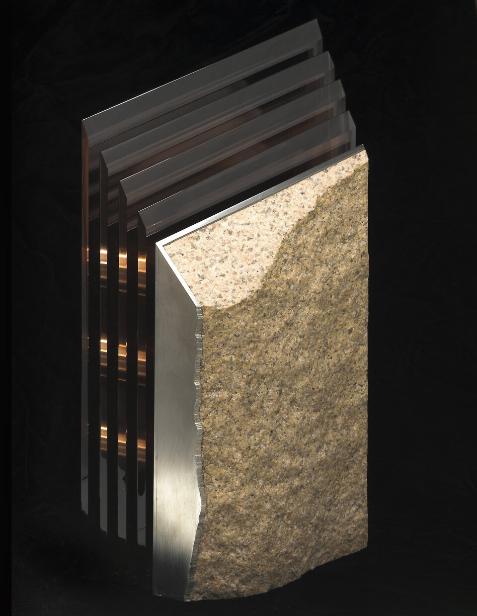 Fotografia przedstawia rzeźbę autorstwa Jack’a Schmidt’a, pod tytułem „#8 Study in Stone”. Kompozycja składa się z wielu warstw wykonanych z  odblaskowego szkła, gładkiego metalu, i grubego granitu.