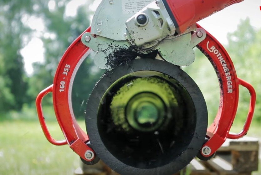 Na zdjęciu widoczna jest rura o średnim przekroju, na której zamocowana została piła z dwoma ramionami zakończonymi rolkami i posiadającymi dwa uchwyty. Rolki umożliwiają obracanie rury podczas cięcia. Poniżej ilustracji znajduje się przycisk do odtworzenia nagrania.