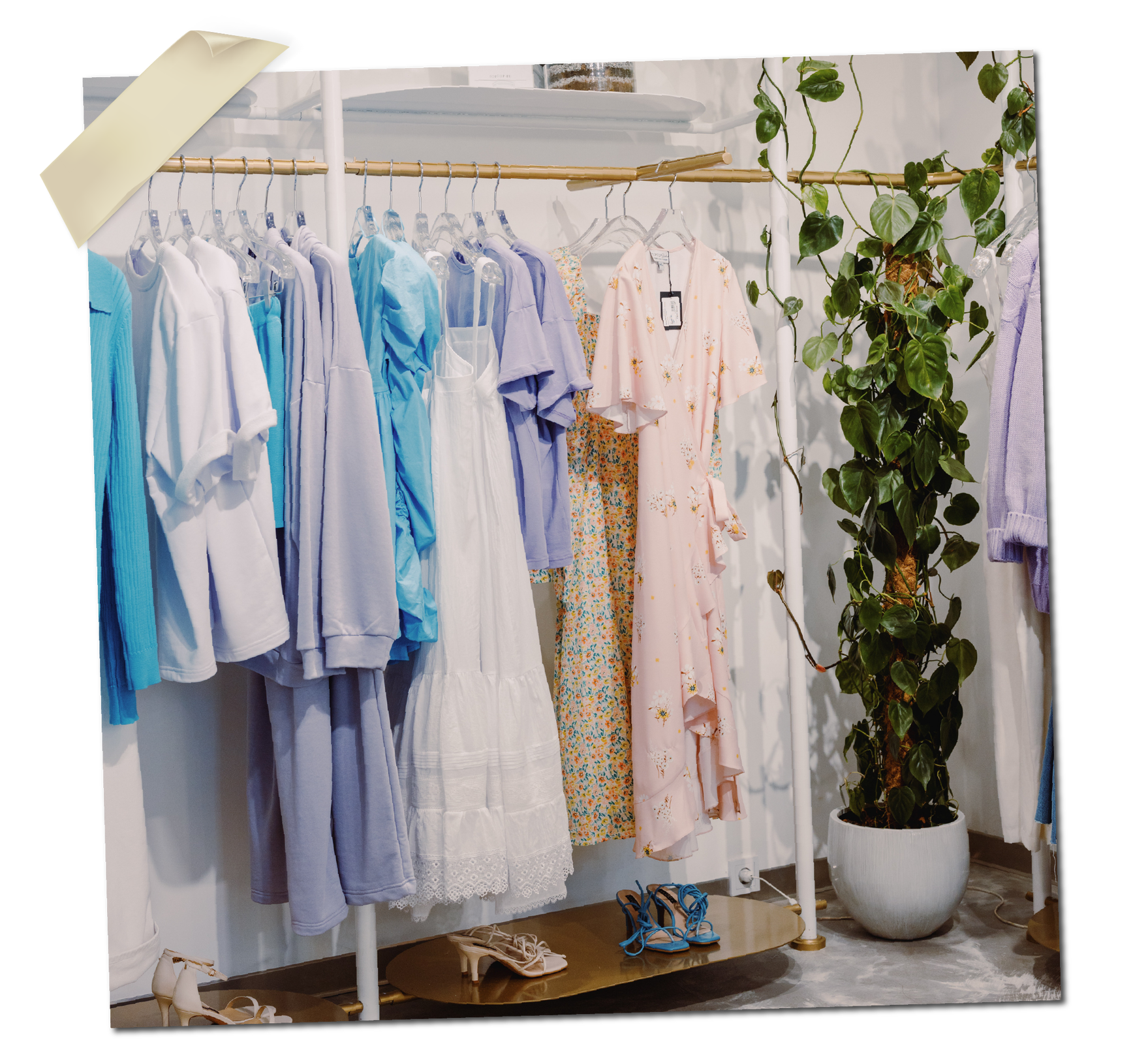 Ilustracja przedstawia wieszak z damskimi jasnymi ubraniami oraz dużą roślinę w doniczce. 
