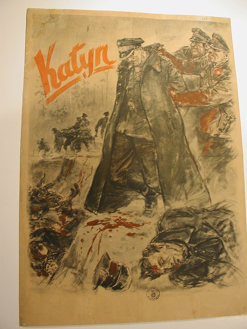 Ilustracja przedstawia plakat, na którym znajduje się napis Katyń. Plakat prezentuje mężczyznę w polskim mundurze, któremu strzelają w głowę dwaj żołnierze radzieccy. Żołnierze mają zakrwawione mundury. Na plakacie znajdują się martwe ciała Polaków, część z nich leży w wykopanym dole.