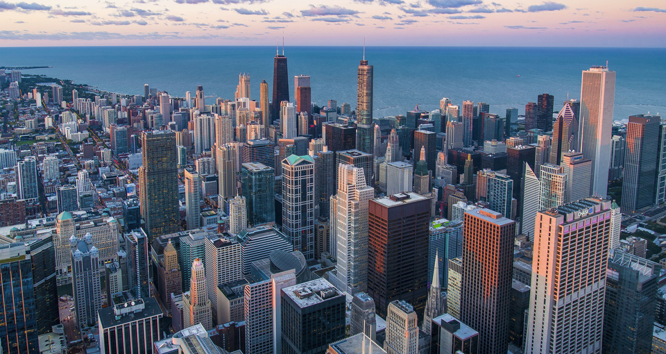 Ilustracja przedstawia widok wieżowców Nowego Yorku z lotu ptaka. 