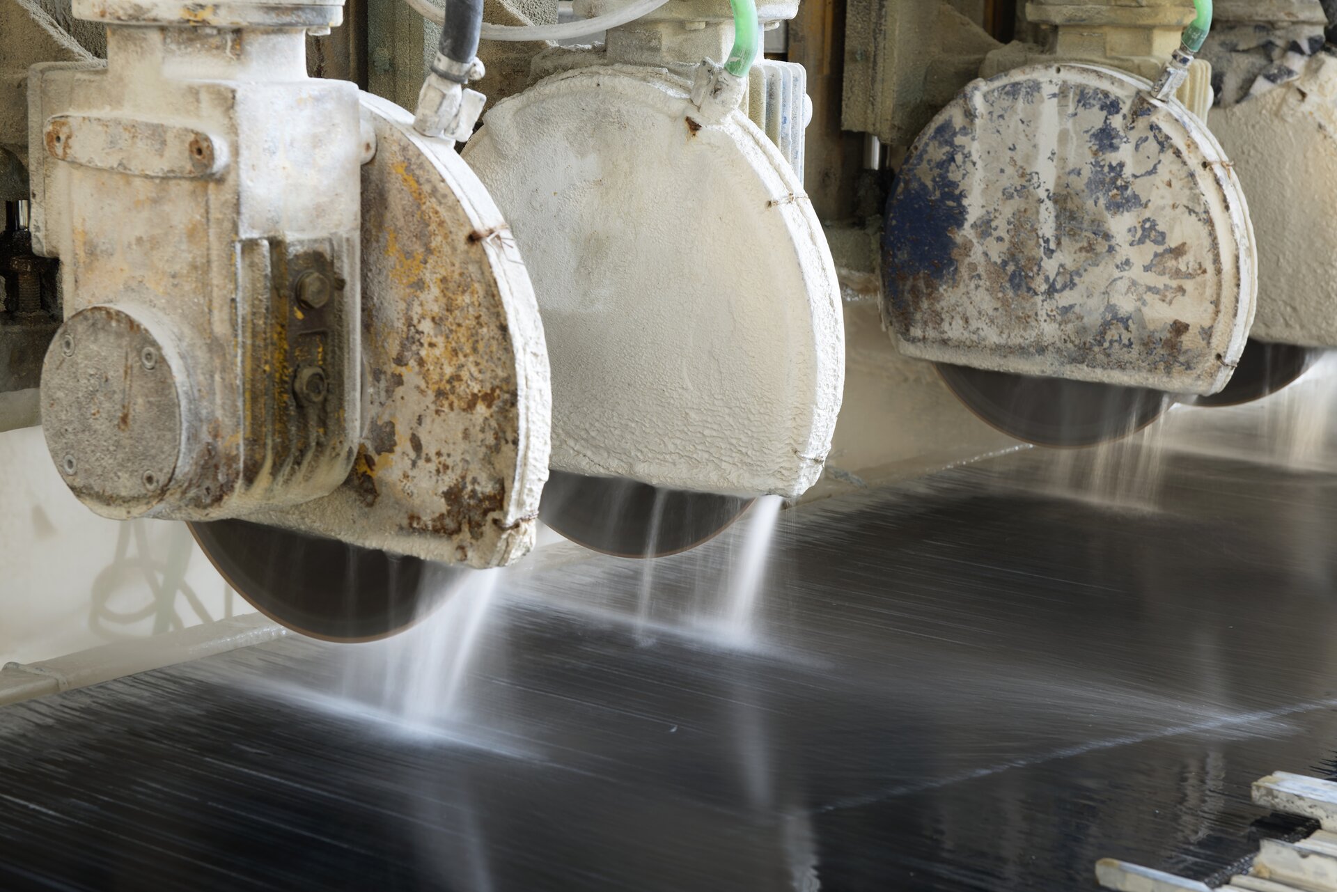 Zdjęcie przecinarki wielotarczowej. Widoczne są cztery tarcze tnące zawieszone nad stołem roboczym.