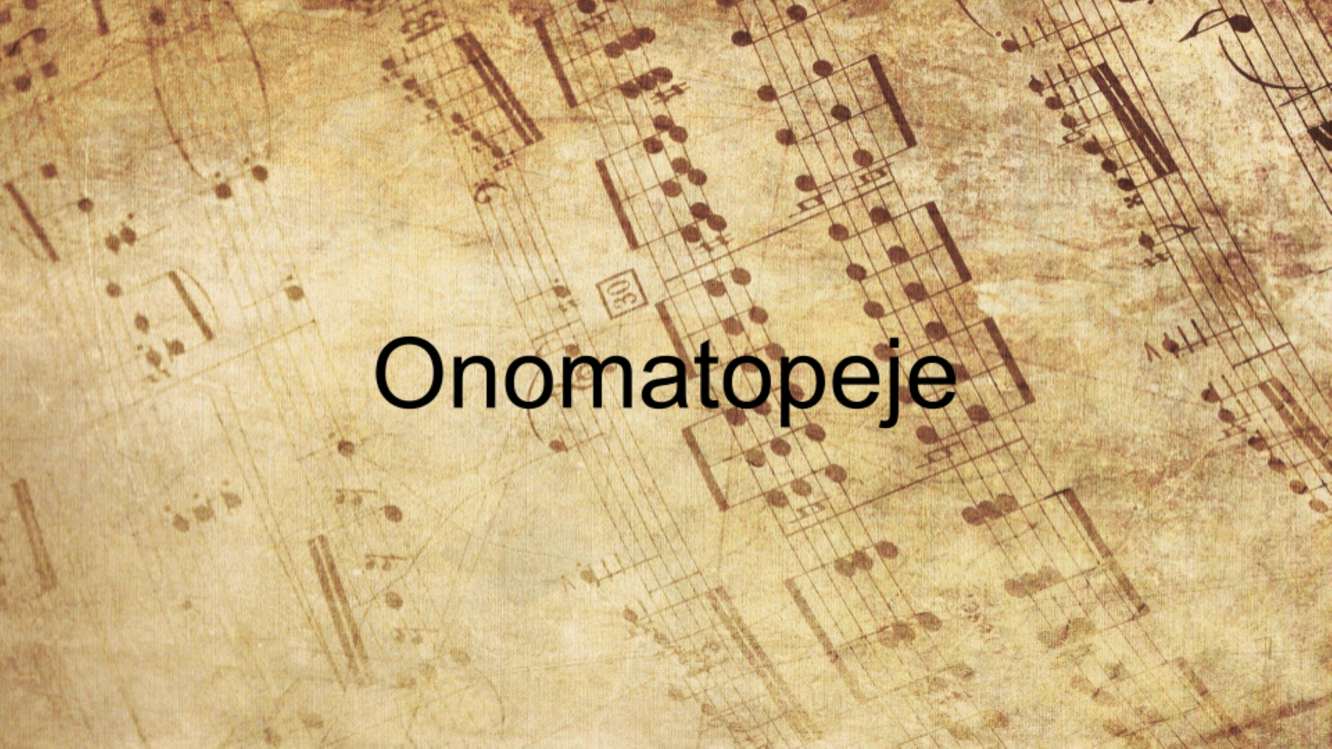 Slajd przedstawia pożółkłą kartkę z wyblakłym zapisem nutowy. Pośrodku widoczny jest napis: Onomatopeje.