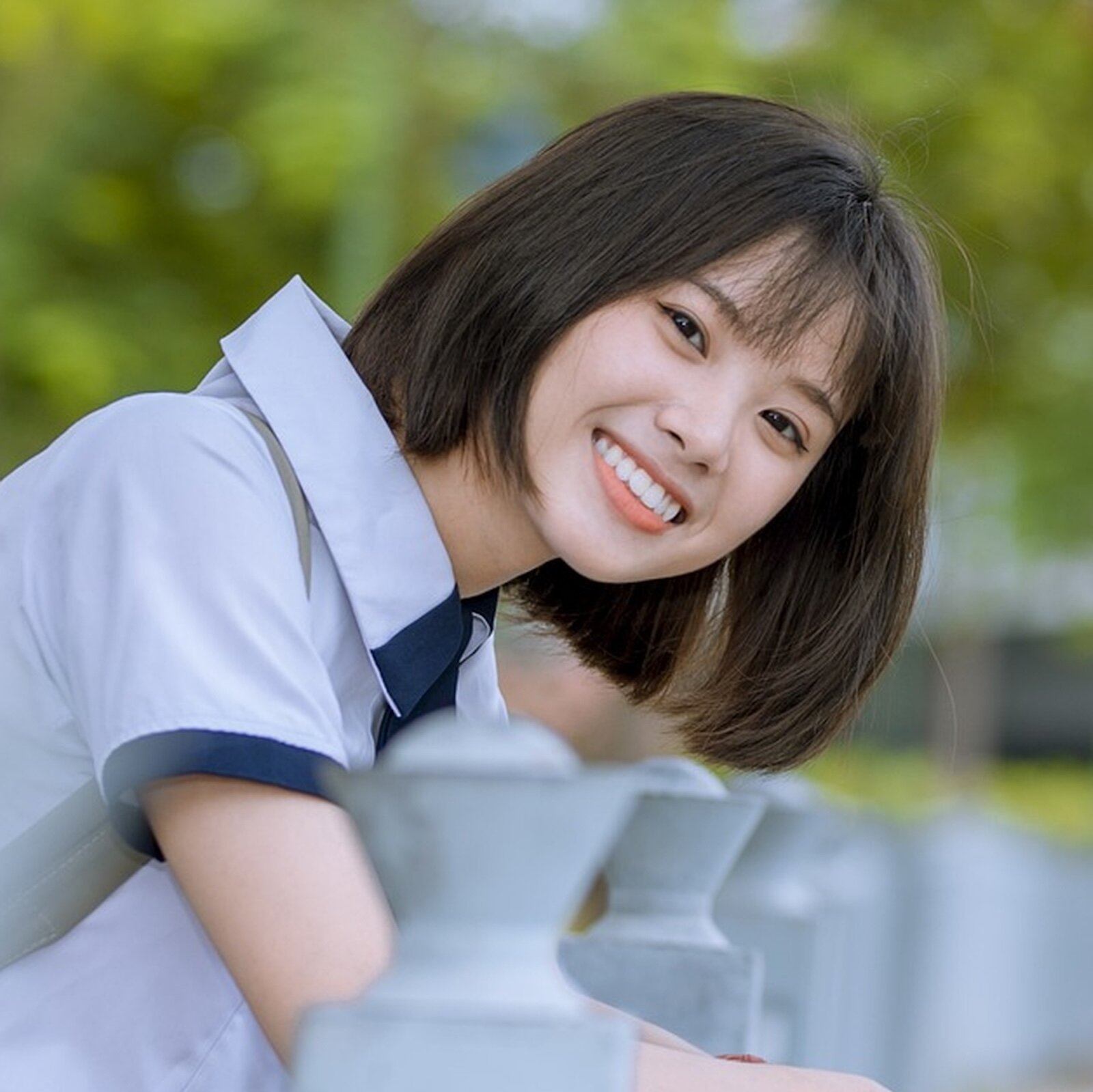 Na zdjęciu widoczna jest młoda kobieta. Ma azjatycką urodę, proste czarne i krótkie włosy, uśmiecha się. 