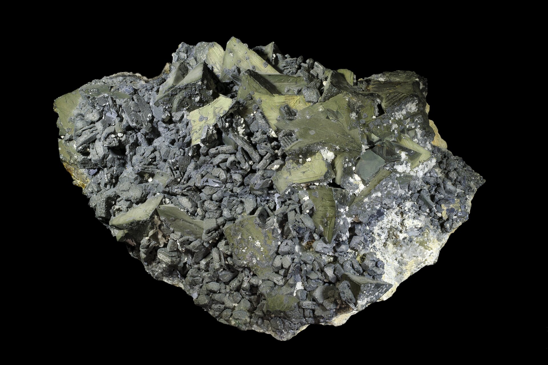 Na zdjęciu jest minerał zbudowany z drobnych, szarych, podłużnych ziaren. Pomiędzy nimi są płaskie kamienie o zielonożółtym odcieniu. 