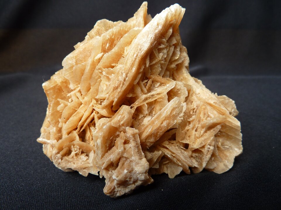 Zdjęcie przedstawia gips. Tworzy zlepione ze sobą ostre kryształy. Ma żółtawą barwę.