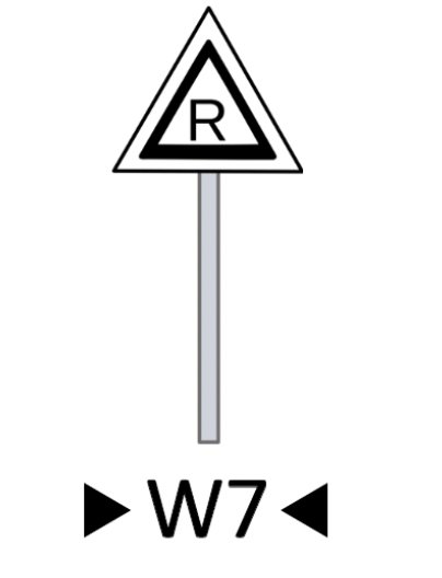 Wskaźnik wu siedem. Trójkąt równoboczny osadzony na słupku. Trójkąt jest biały i ma czarny kontur. W trójkącie znajduje się wielka litera er.