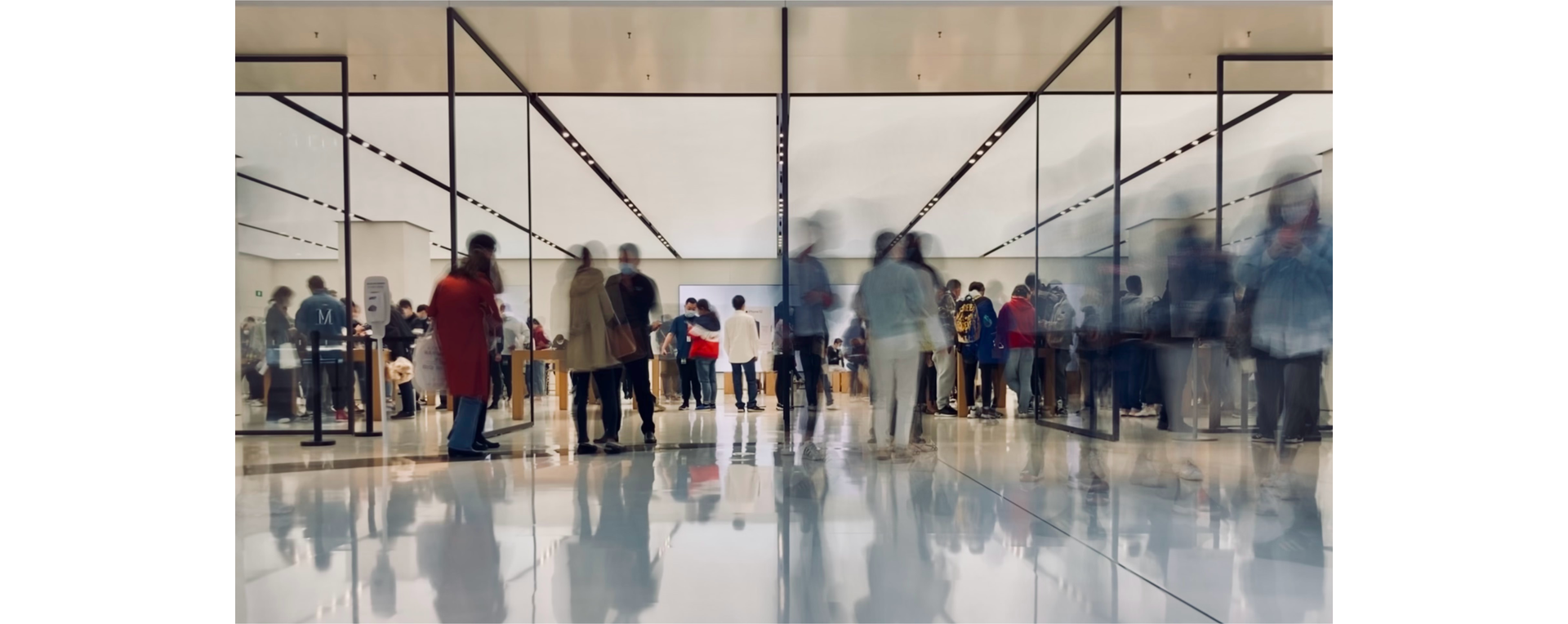 Zdjęcie przedstawia halę lotniskową. Na lekko rozmytym zdjęciu widoczni są ludzie.