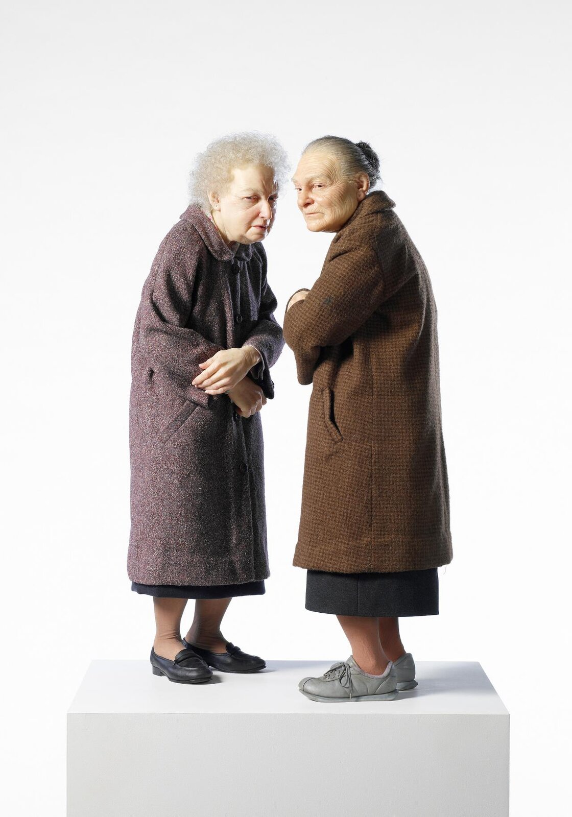 Przedstawiona rzeźba ukazuje dwie starsze kobiety. Jedna z nich posiada białe, kręcone włosy, druga zaś siwe, spięte w koka. Kobieta o kręconych włosach ubrana jest w szaro‑fioletowy, długi płaszcz, czarną spódnicę oraz buty. Druga z nich odziana jest w długi, brązowy płaszcz, czarną spódnicę oraz szare buty. Sylwetki kobiet są nieco zgarbione. Każda z nich trzyma ręce założone na siebie. Spoglądają w stronę obserwatora z grymasami na twarzy. Dzieło ustawione jest na białym postumencie na tle białej ściany.
