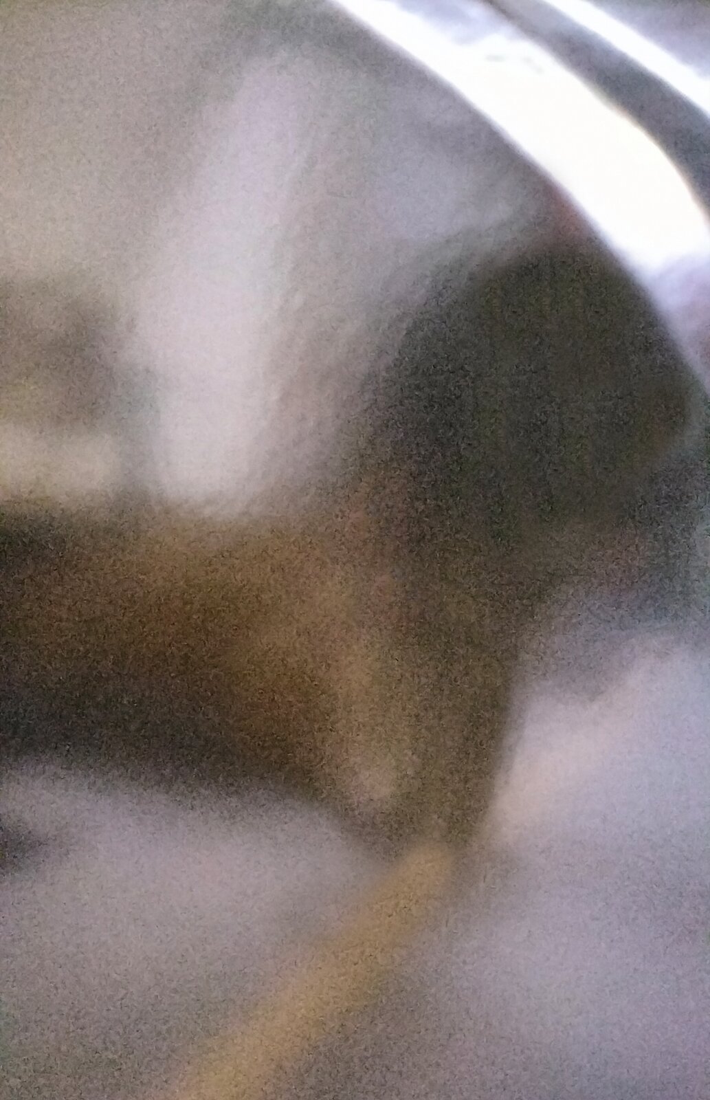 Zdjęcie przedstawia element obudowy fortepianowej polakierowany czarnym lakierem poliestrowym. Widoczna jest rozmyta błyszcząca powierzchnia w kolorze srebrnym.