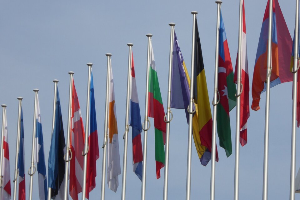 Zdjęcie przedstawia łopoczące na wietrze flagi państw europejskich.