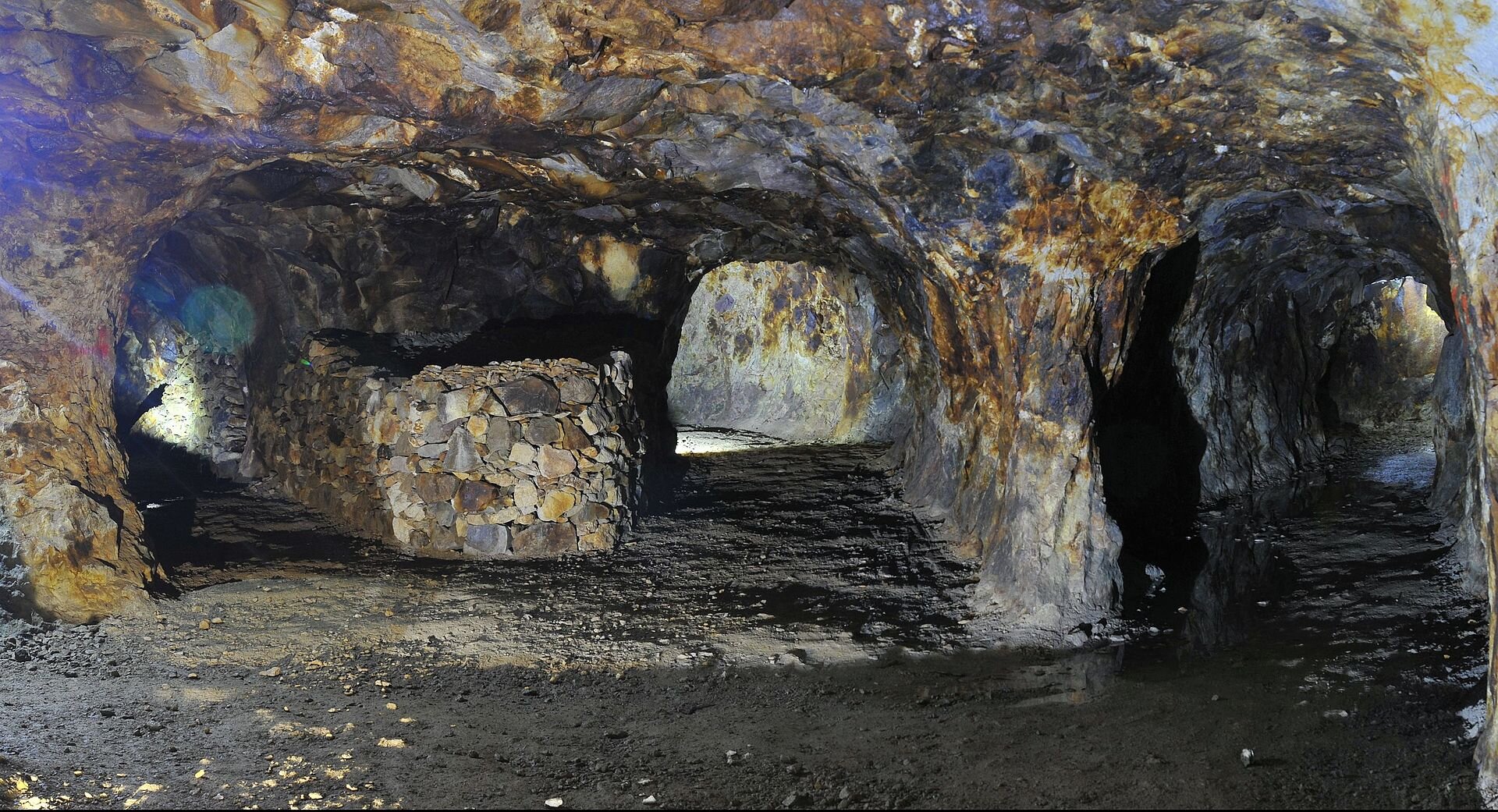 Zdjęcie rozgałęziających się tuneli w kopalni. Są niskie i wąskie, wykute w skale.