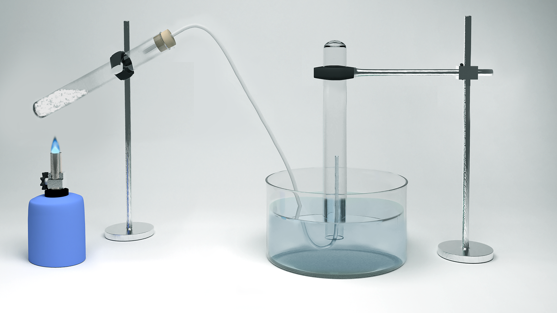 Ilustracja przedstawia zestaw do otrzymywania tlenu. Jedna probówka z białym proszkiem jest umieszczona w łapie statywu, pod nią znajduje się zapalony palnik. Zatkana jest korkiem z rurka odprowadzającą, której drugi koniec umieszczony jest w drugiej probówce wypełnionej woda i odwróconej do góry dnem w krystalizatorze z wodą. Probówka również zamontowana jest w łapie statywu.