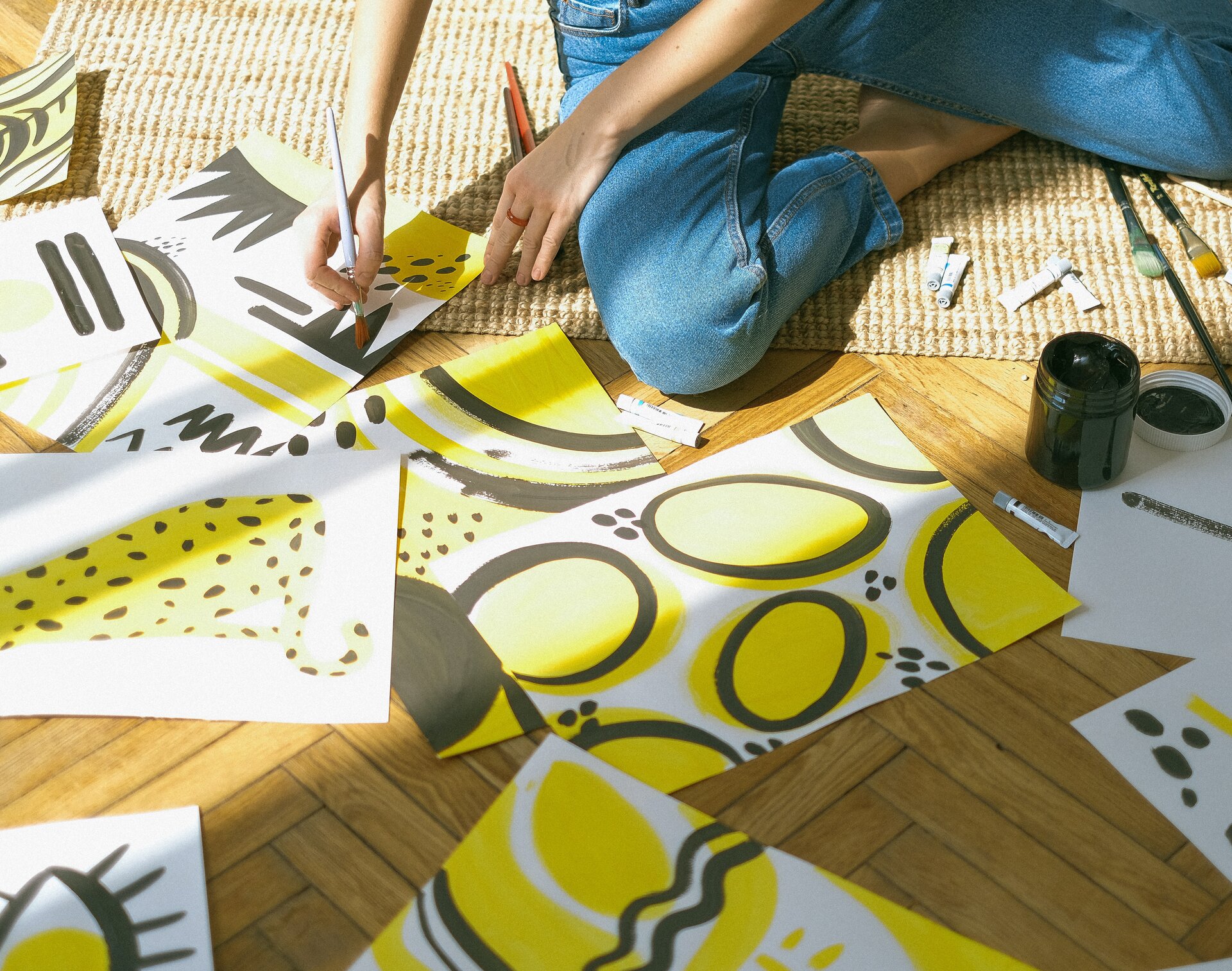 Ilustracja przedstawia malującą farbami osobę