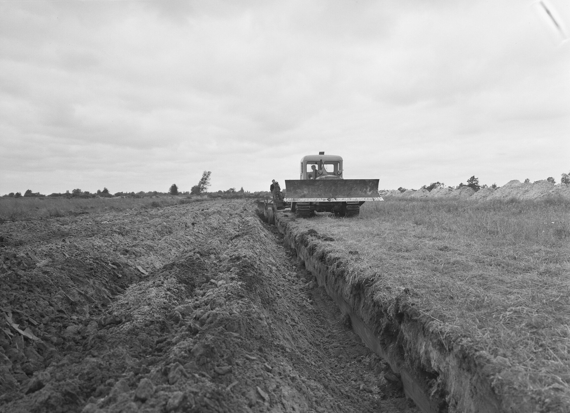 Zdjęcie przedstawia rekultywację nieużytków. Widać spycharkę jadącą po nieużytku.