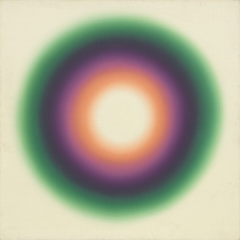 Ilustracja w formie kwadratu przedstawia kolorowe okręgi ustawione jeden w drugim na beżowym tle. Okręgi mają cztery warstwy; pierwsza zewnętrzna ma kolor zielony, druga ma kolor fioletowy, trzecia ma kolor pomarańczowy, a czwarta wewnętrzna, stanowiąca centrum, koloru jasno żółtego.