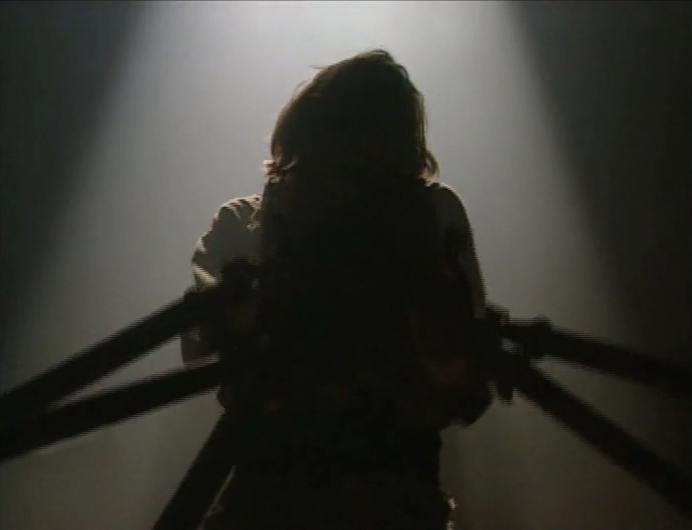 Zdjęcie przedstawia kadr z filmu. Znajduje się na nim postać Winkelrida, w którego skierowane są ostrza broni. Postać mężczyzny jest ocieniona, podświetla ją od tyłu snop światła.