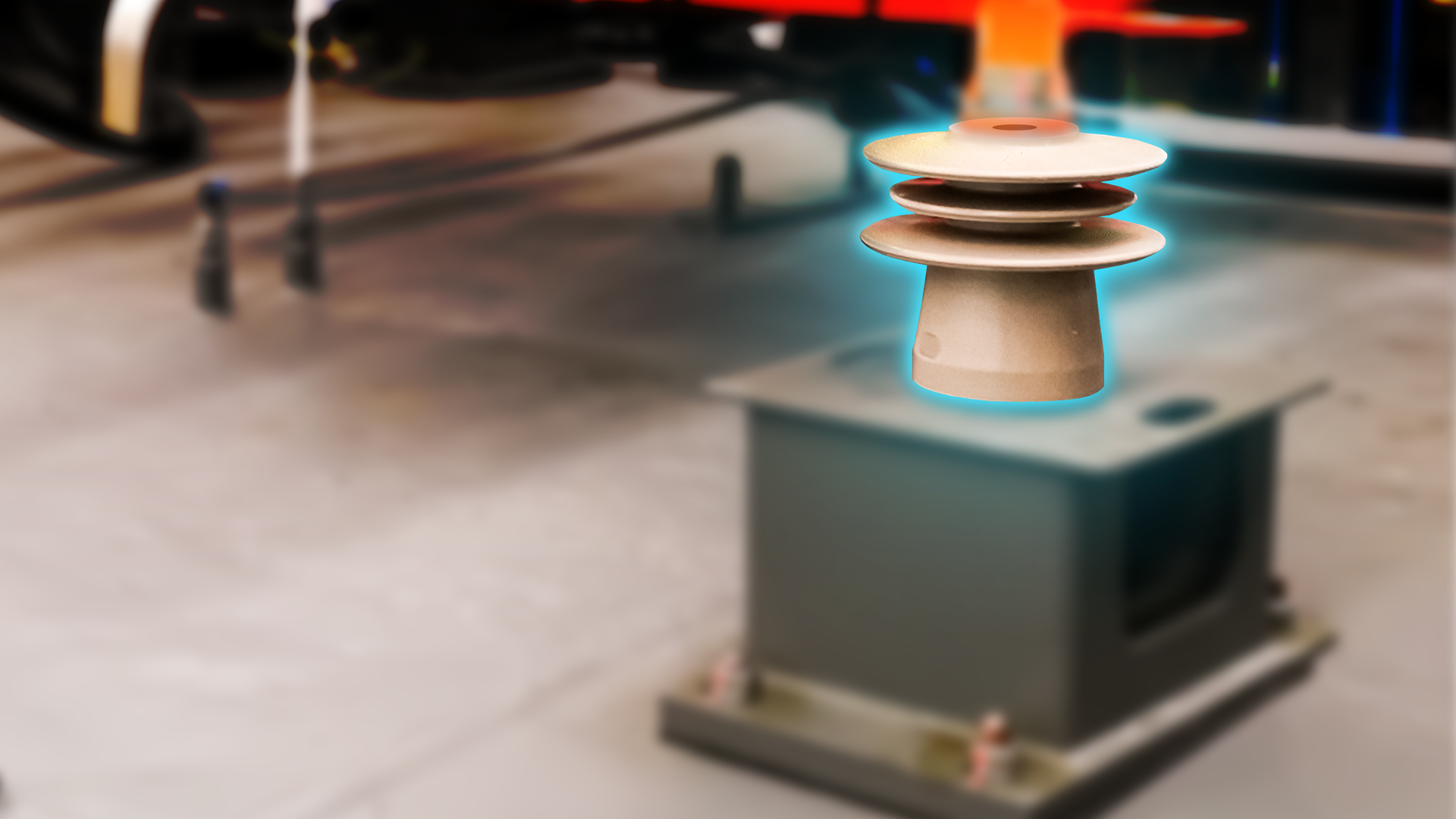 Zdjęcie przedstawia izolator wsporczy pantografu. Izolator jest wyróżniony ze zdjęcia, wszystko wokół jest niewyostrzone. Ma on kształt grzyba z trzema kapeluszami ustawionymi jeden na drugim. Środkowy kapelusz ma mniejszą średnicę niż pozostałe dwa.