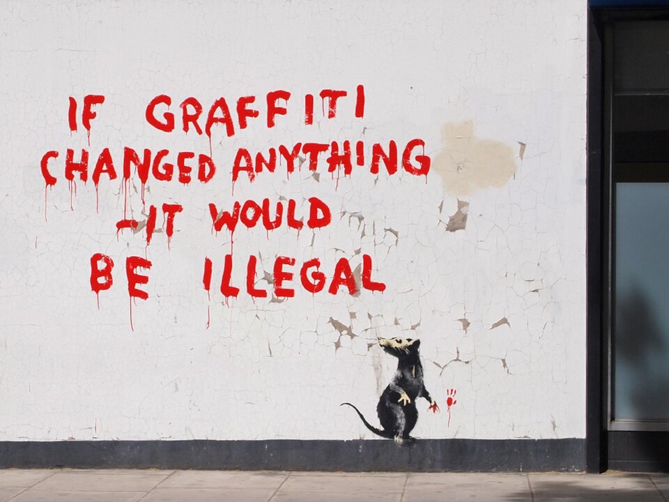 Ilustracja przedstawia dzieło Banksy pt. „If Graffiti Changed Anything”. Zaprezentowany został fragment białej ściany, na której pojawił się angielski fragment tekstu. Wykonany on został czerwoną farbą. Poniżej szczególną uwagę zwraca grafika szczura. Praca znajduje się na jednej z londyńskich ulic. Twórca dzieła słynie ze stosowania nurtu street art. Banksy w swoich pracach przekazuje odbiorcą wiadomości najczęściej w formie humorystycznej.