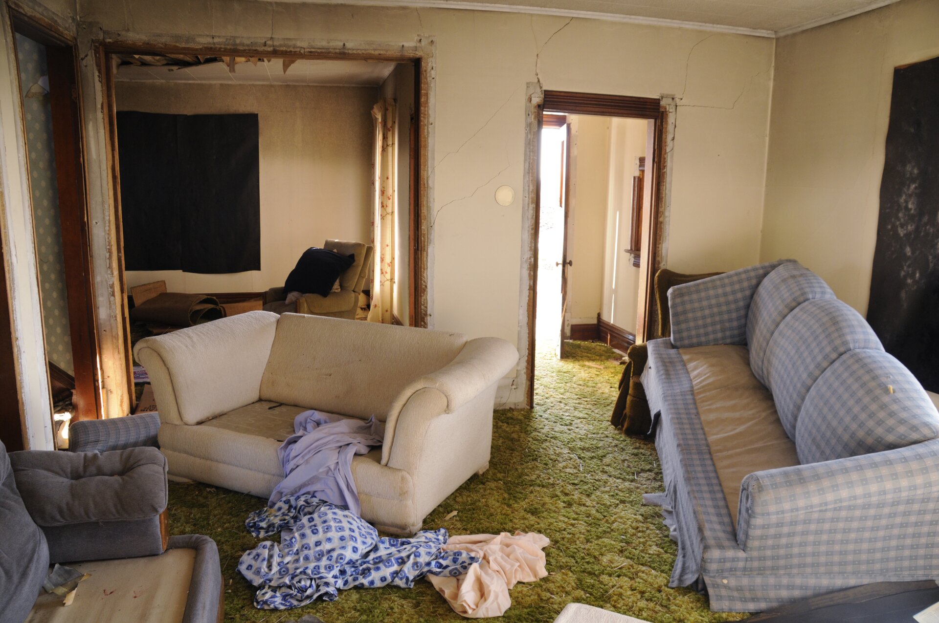 Zdjęcie przedstawia degradację tynku wewnętrznego po opadnięciu wody powodziowej. Widoczne są liczne jego spękania.