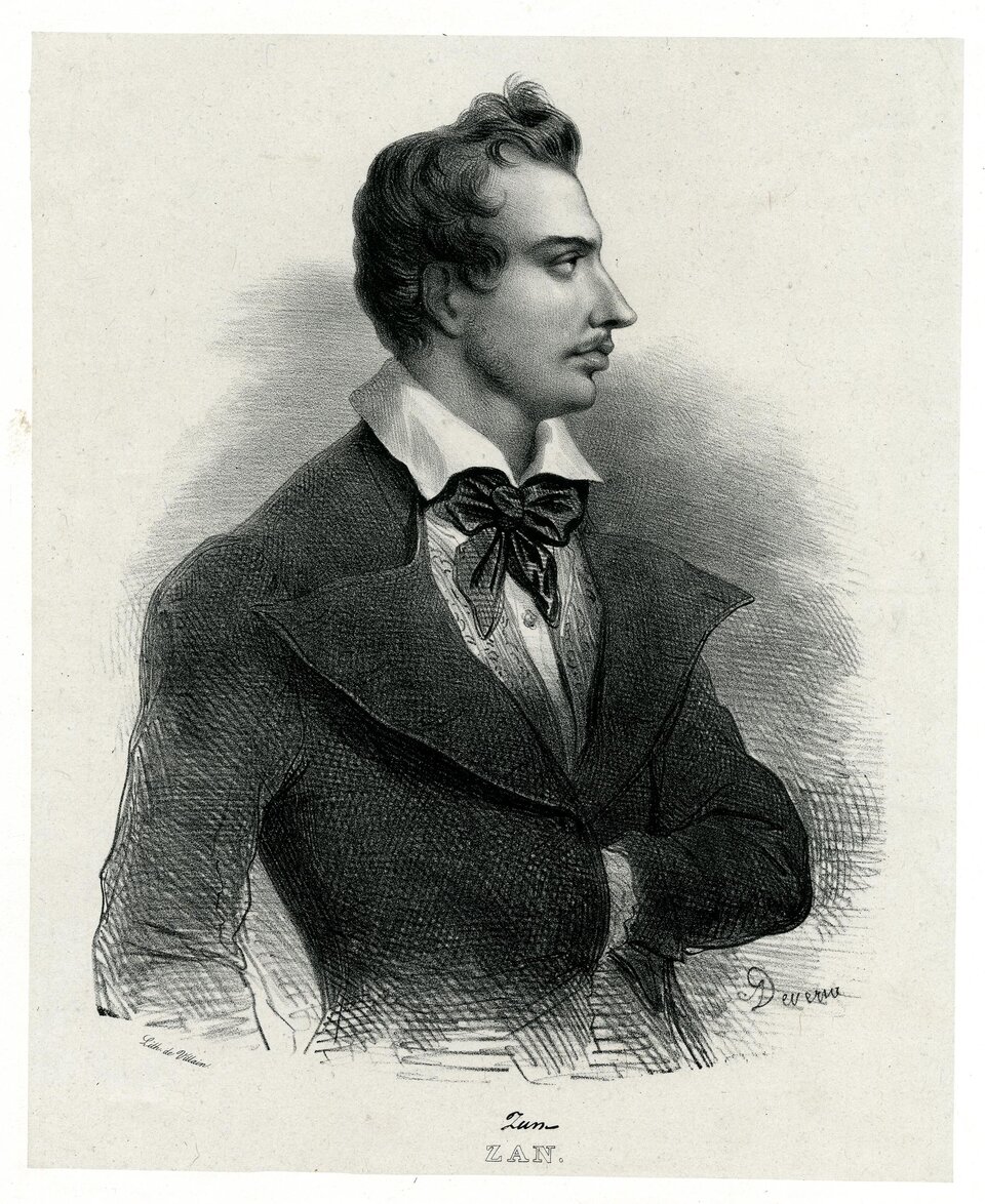 Ilustracja przedstawia młodego mężczyznę. Ukazany jest z prawego profilu. Ma krótkie, lekko falowane, zaczesane do góry włosy, które ukazują wysokie czoło, szczupłą twarz, wyraziste oczy, wąski, długi nos i krótki wąsik. Ubrany jest w marynarkę z dużymi, rozłożystymi klapami, kamizelkę, białą koszulę z wykładanym kołnierzykiem, a pod szyją ma zawiązaną apaszkę. Lewą rękę ma schowaną za poły marynarki.