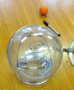 Zdjęcie przedstawia przeźroczystą kulę, na której narysowano czworokąt. Kąty wewnętrzne w czworokącie są następujące: 90, 90, 115 i 115 stopni, razem 410 stopni.