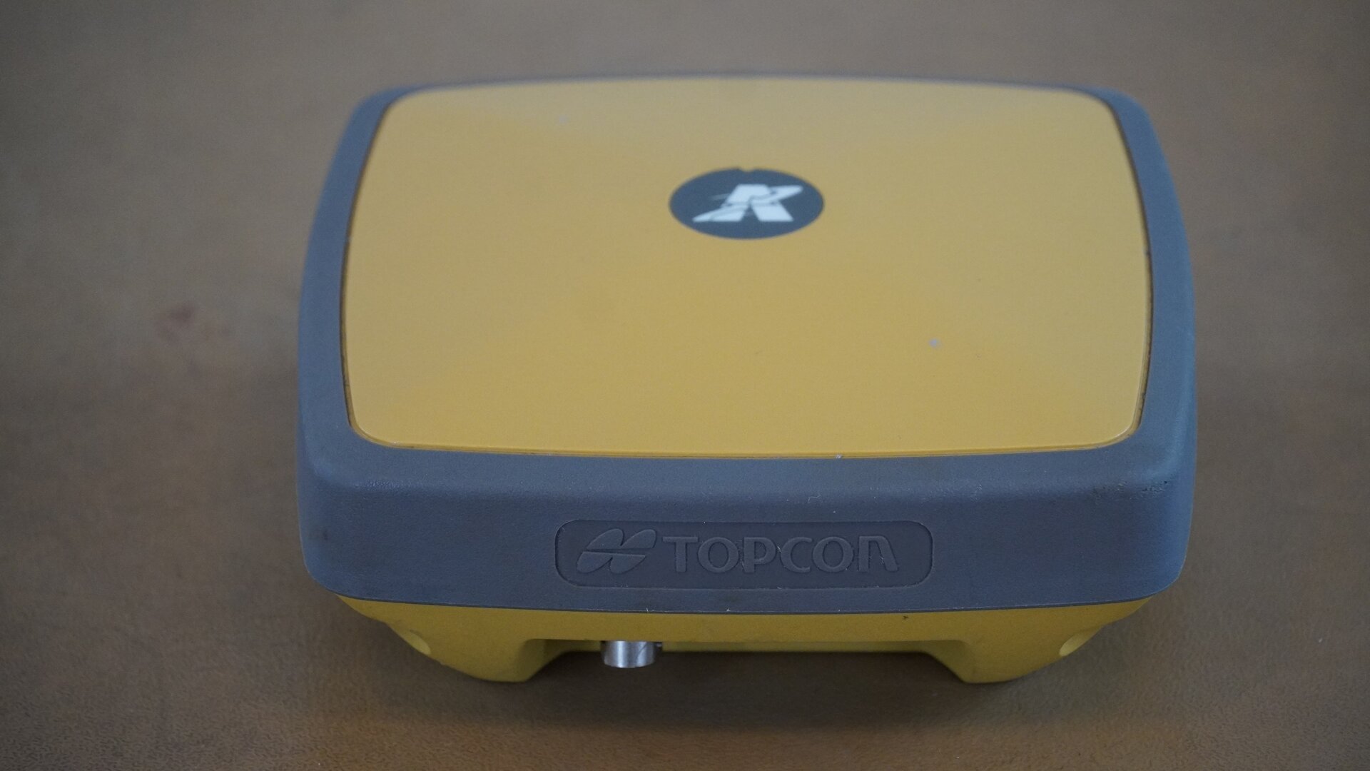 Zdjęcie ukazuje odbiornik GNSS. Urządzenie ma postać niewielkiego pudełka.