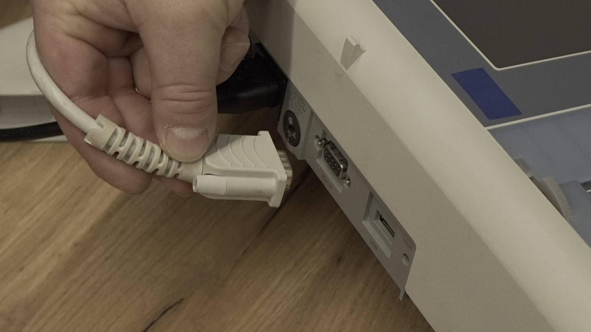 Zdjęcie przedstawia podpinanie przewodu do gniazda RS‑232.