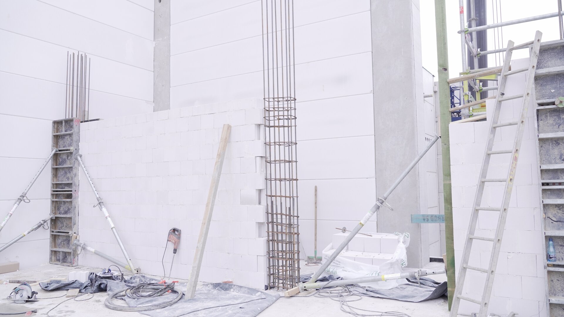 Zdjęcie przedstawia zbrojenie słupa znajdującego się wewnątrz budynku o białych, kamiennych ścianach.