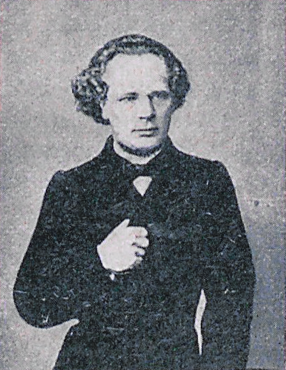 Ilustracja przedstawia mężczyznę w średnim wieku z nieco dłuższymi włosami zaczesanymi do tyłu. Mężczyzna ma wysokie, odkryte czoło, długi, prosty nos, wydatne usta, niewielki zarost na brodzie. Ubrany jest w ciemny surdut i muszę pod szyją.