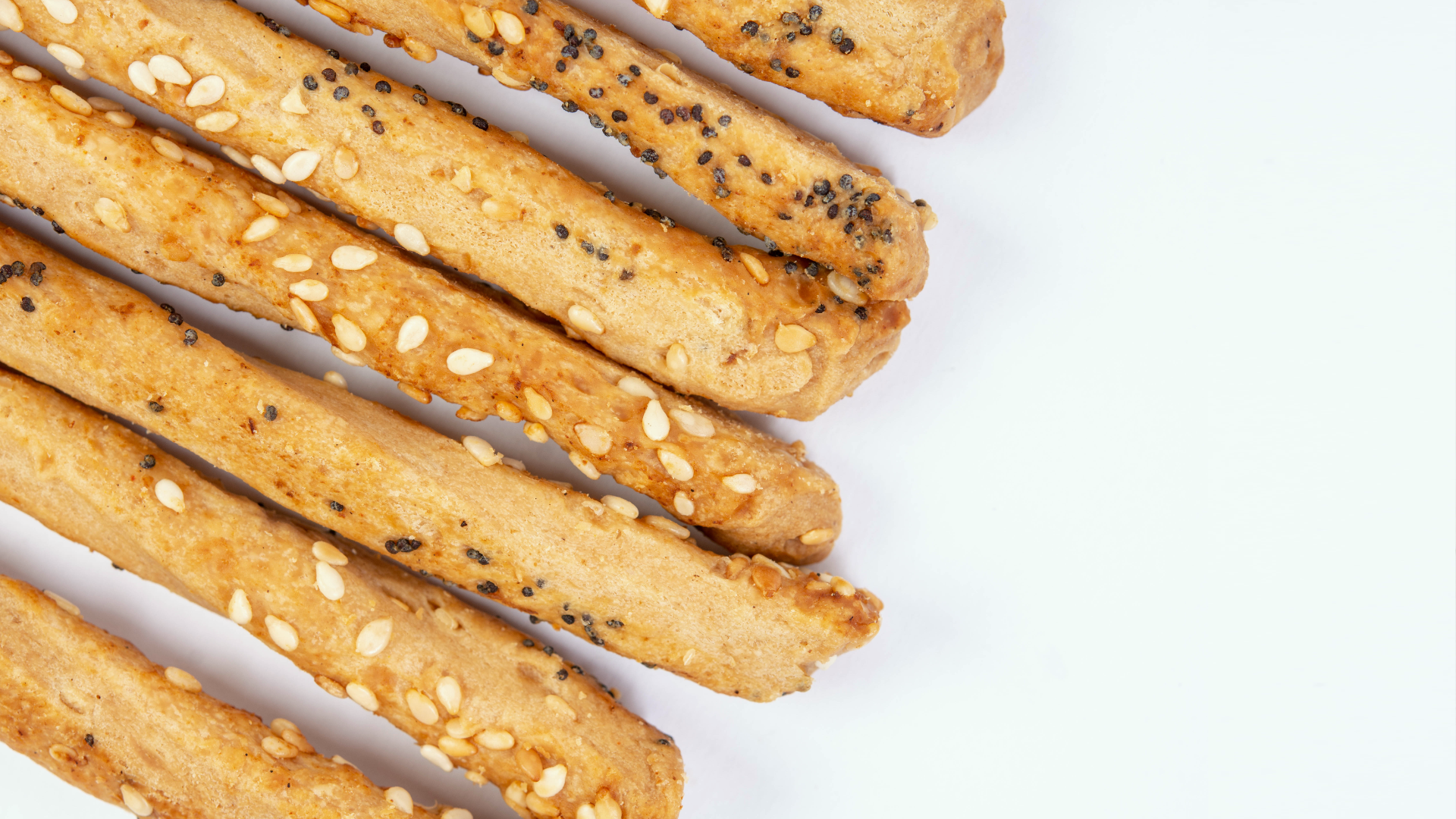 Zdjęcie przedstawia paluszki Grissini. Paluszki posypane są sezamem i makiem.