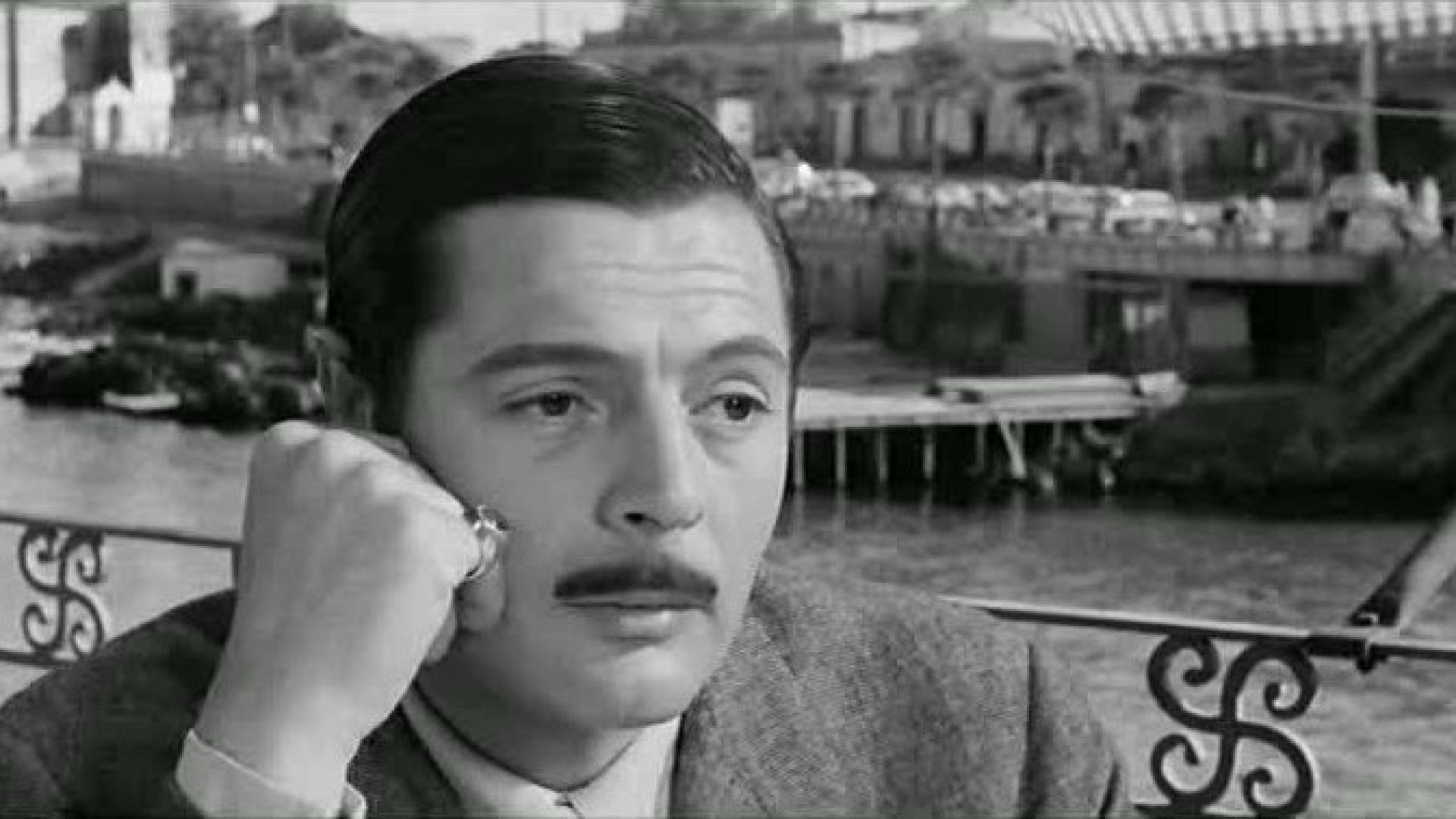 Zdjęcie przedstawia kadr z filmu Divorzio all'italiana Pietra Germiego. Zdjęcie przedstawia zbliżenie na głowę mężczyzny z wąsami. Jego włosy uczesane są na bok. Prawą ręką podpiera policzek.