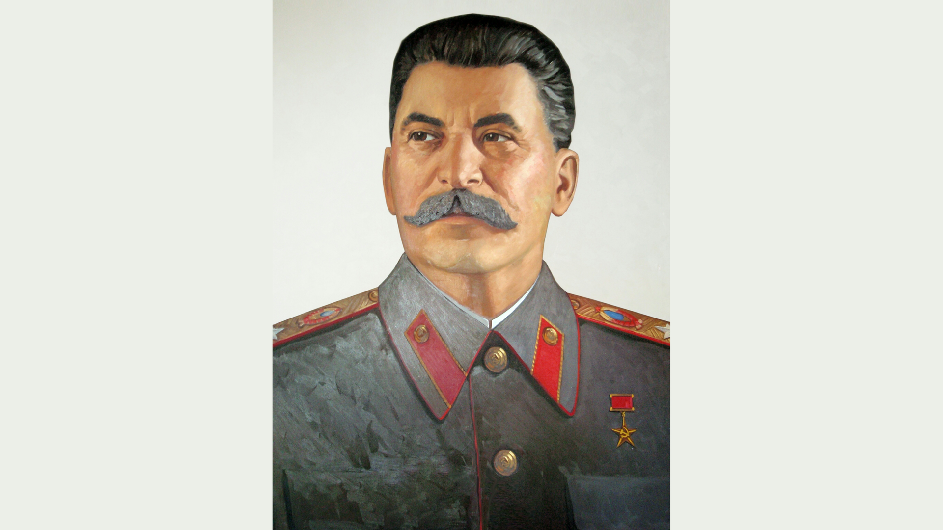 Zdjęcie przedstawia portret Józefa Stalina. Mężczyzna ubrany jest w mundur z pagonami. Włosy ma zaczesane do tyłu oraz duży wąs.