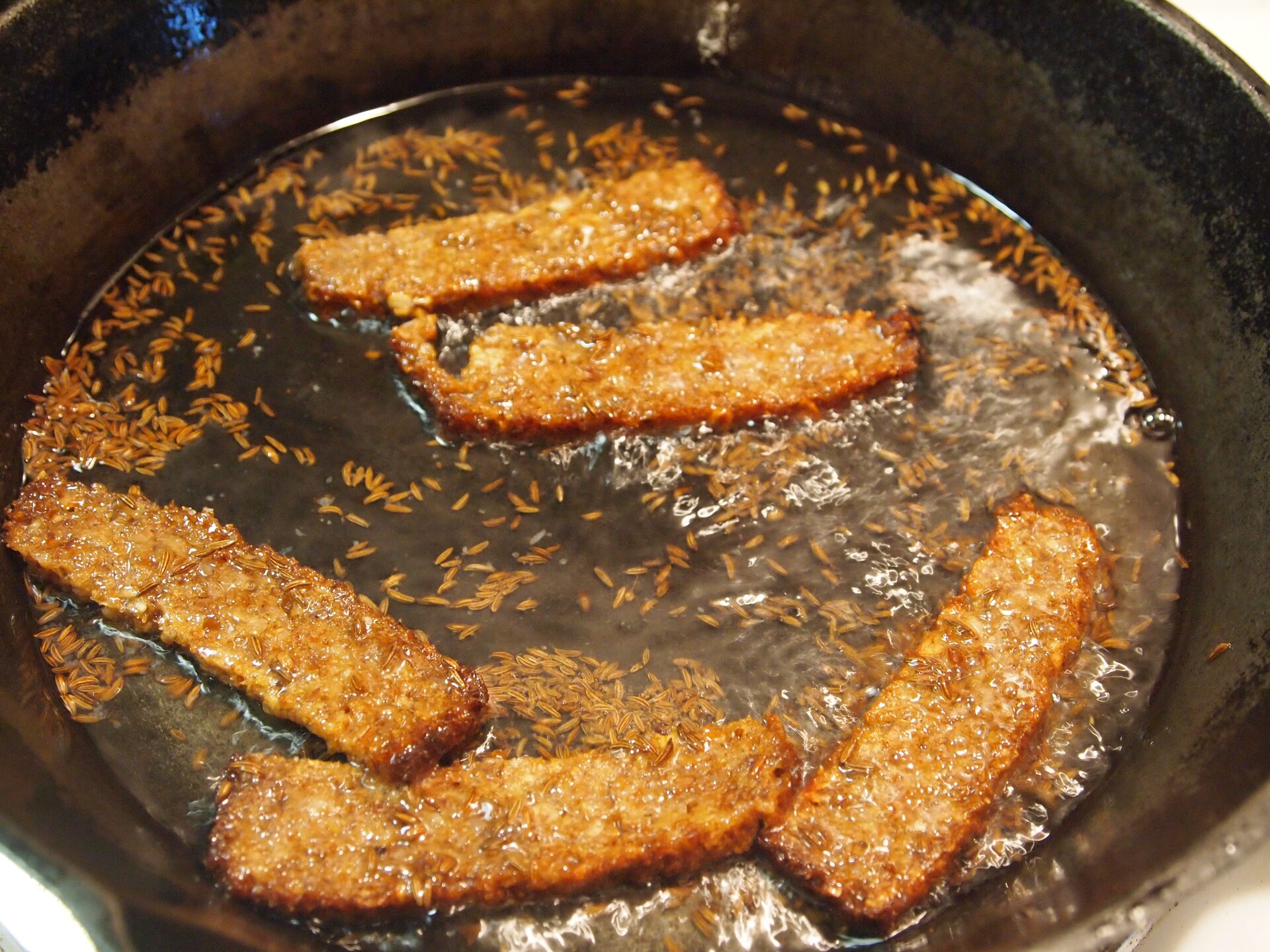 Smażony na patelni chleb żytni posypany kminkiem.