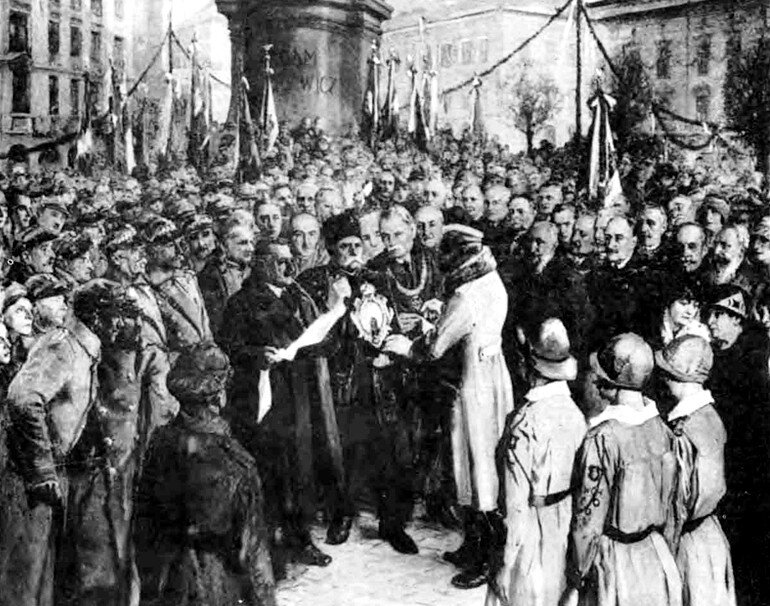 Fotografia przedstawia tłum ludzi, w samym środku stoi mężczyzna, który wręcza drugiemu medal. Obok stoi trzech żołnierzy na baczność.